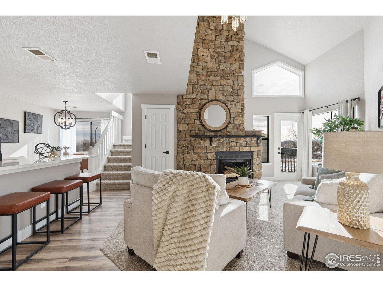 Image 1: Where warmth meets wow-this open, inviting space is centered around a stunning fireplace.