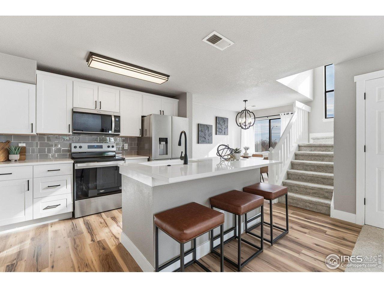 Image 2: Sleek new kitchen: quartz counters, modern cabinets & appliances.
