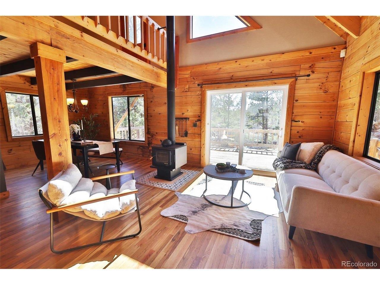 Image 1: The living room is warm and inviting, centered around a wood-burning stove that efficiently heats the entire home.