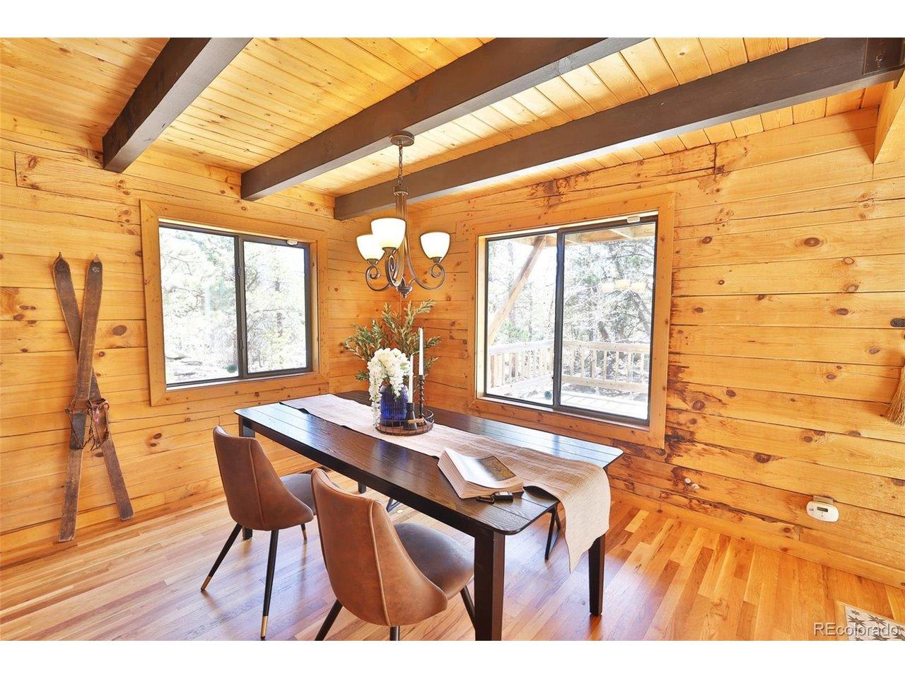 Image 4: The dining room offers beautiful views and flows seamlessly into the kitchen and living room, all anchored by a cozy wood stove that adds warmth and charm.