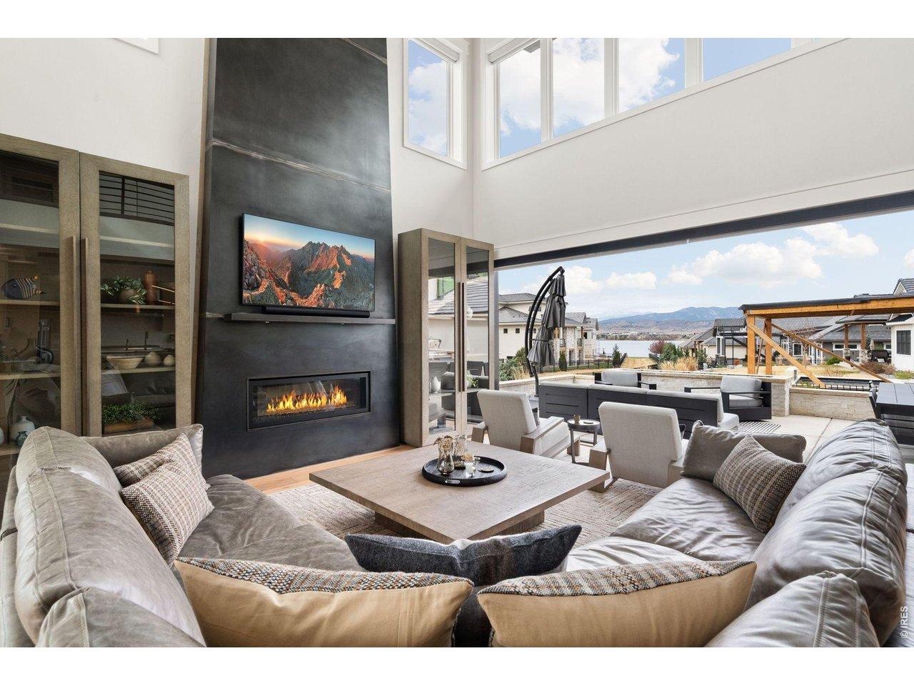 Image 4: Living room with 21ft ceilings and 18 ft accordion door with lake and mountain views