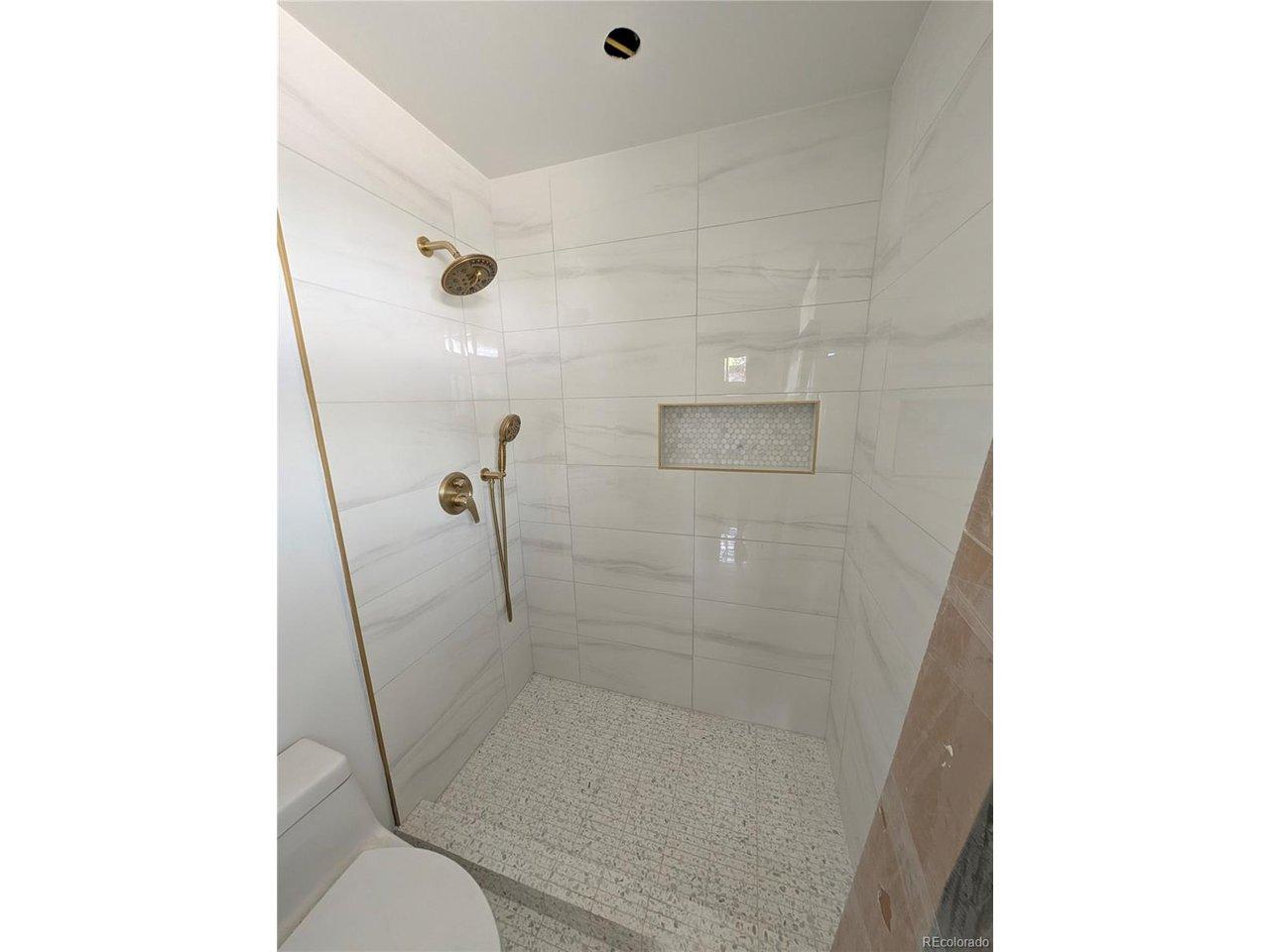 Image 4: Updated shower area with tile surround and built-in niche.