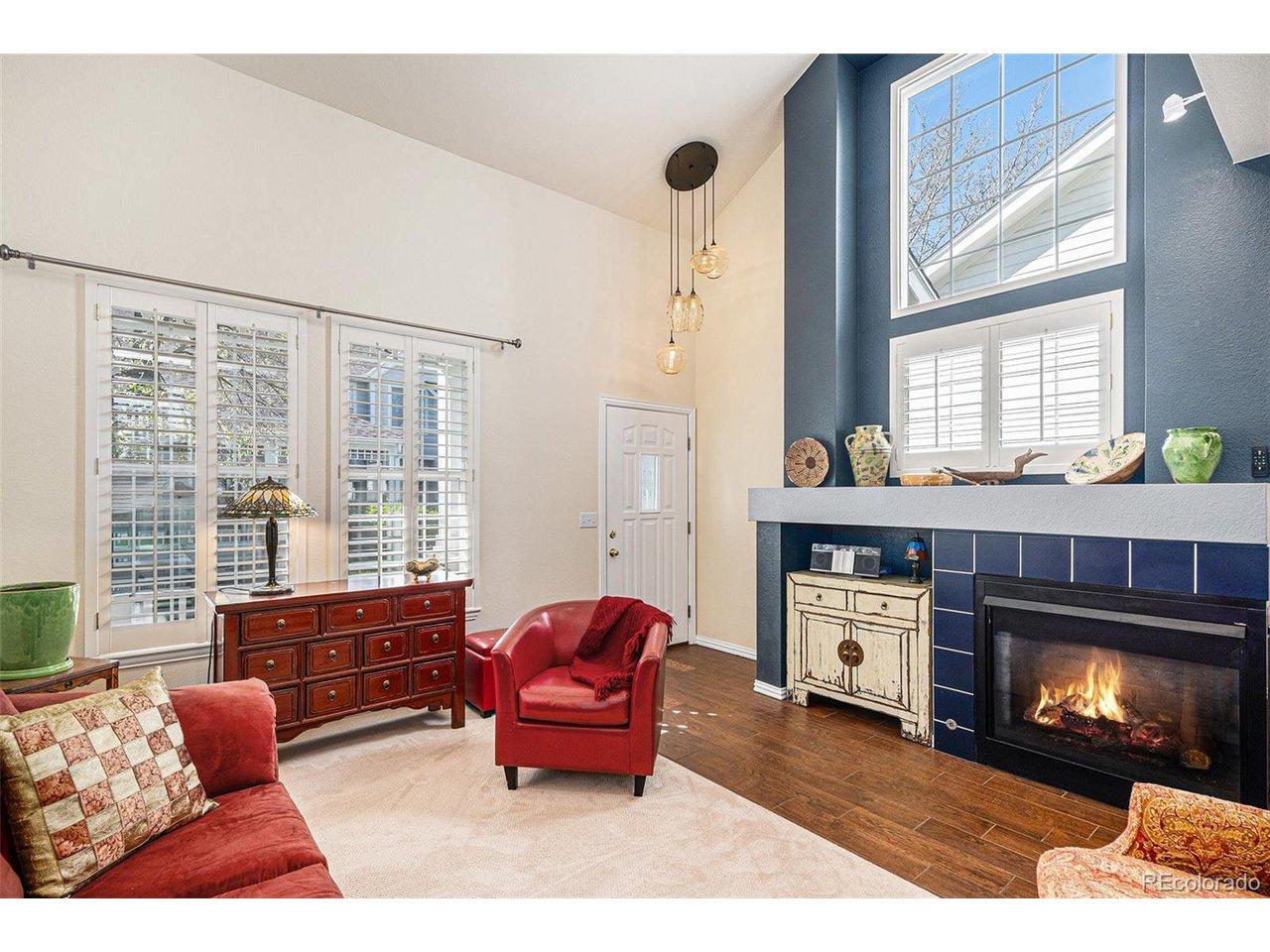 Image 1: Living room with large windows and gas fireplace. Notice the dramatic entryway light fixture. Image 1: Living room with large windows and gas fireplace. Notice the dramatic entryway light fixture.