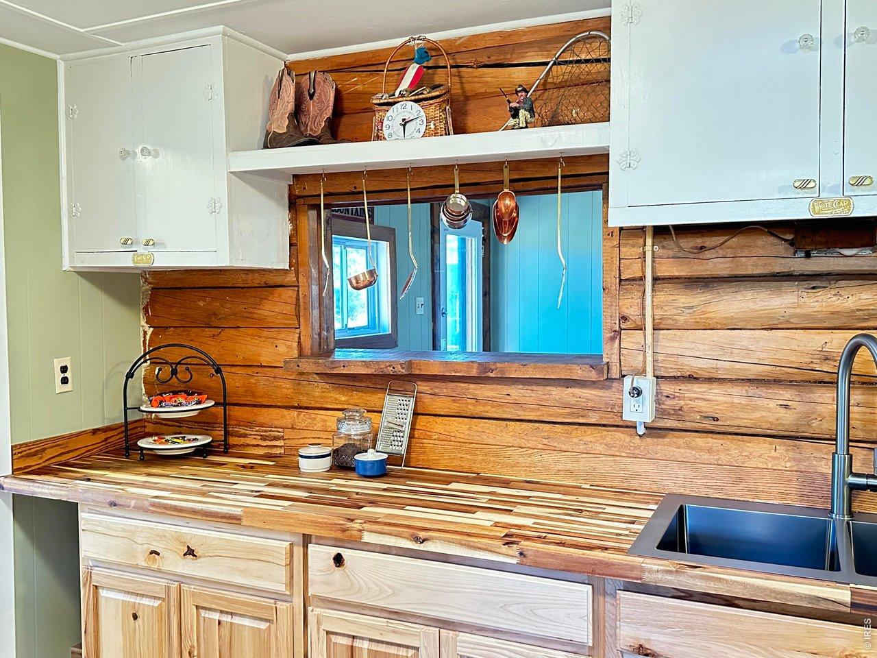 Image 4: Original Logs and upper cabinets keep the rustic charm Image 4: Original Logs and upper cabinets keep the rustic charm