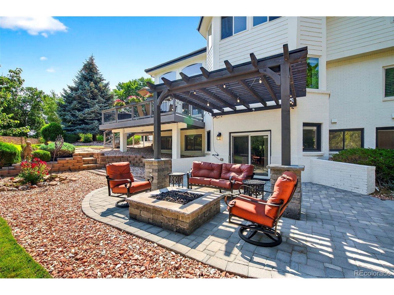Image 2: Custom fire pit, pergola and stone patio offers the perfect place to unwind.