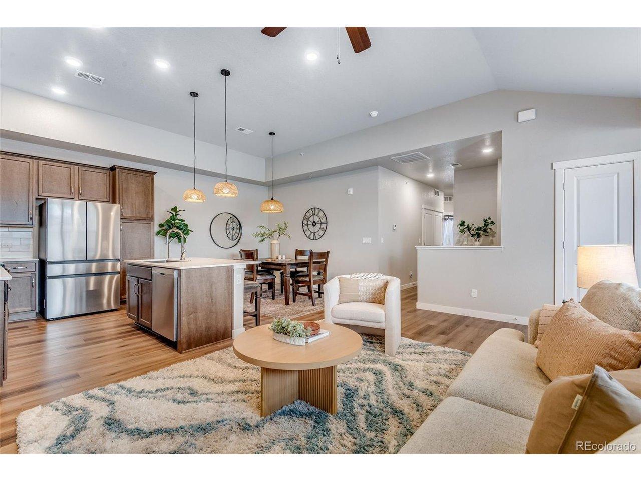 Image 3: Higher ceilings, an expansive living room, oversized high-end 4 door newer stainless steel fridge!  Upgraded Low maintenance wood LVP flooring! Beautiful upgrades throughout!