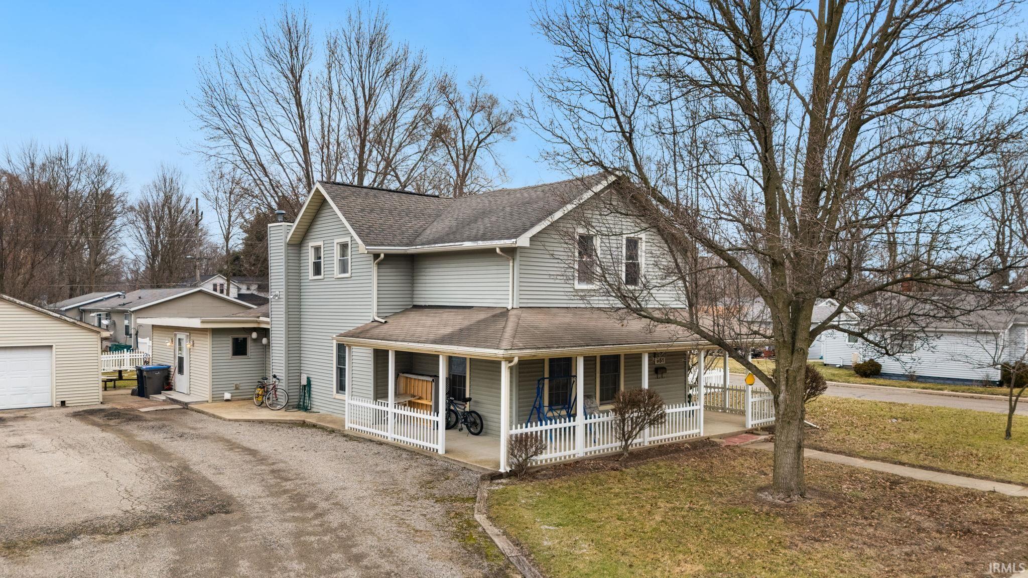 Image 1: View of front of house featuring roof with shingles, covered porch, driveway, and a front lawn, Front Of Structure