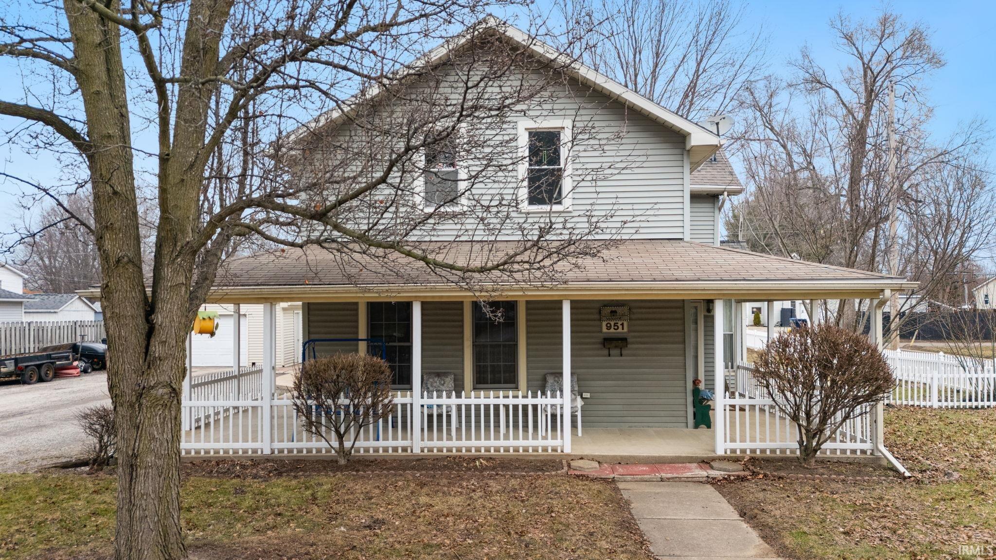Image 2: Farmhouse with a porch and a shingled roof, Front Of Structure