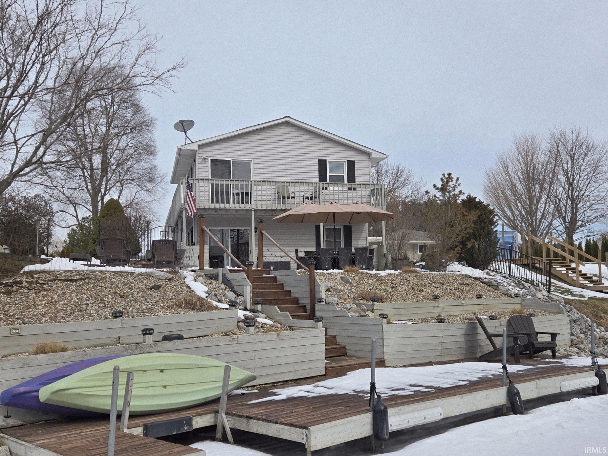 Image 2: Snow covered rear of property featuring stairs and a deck, Back Of Structure