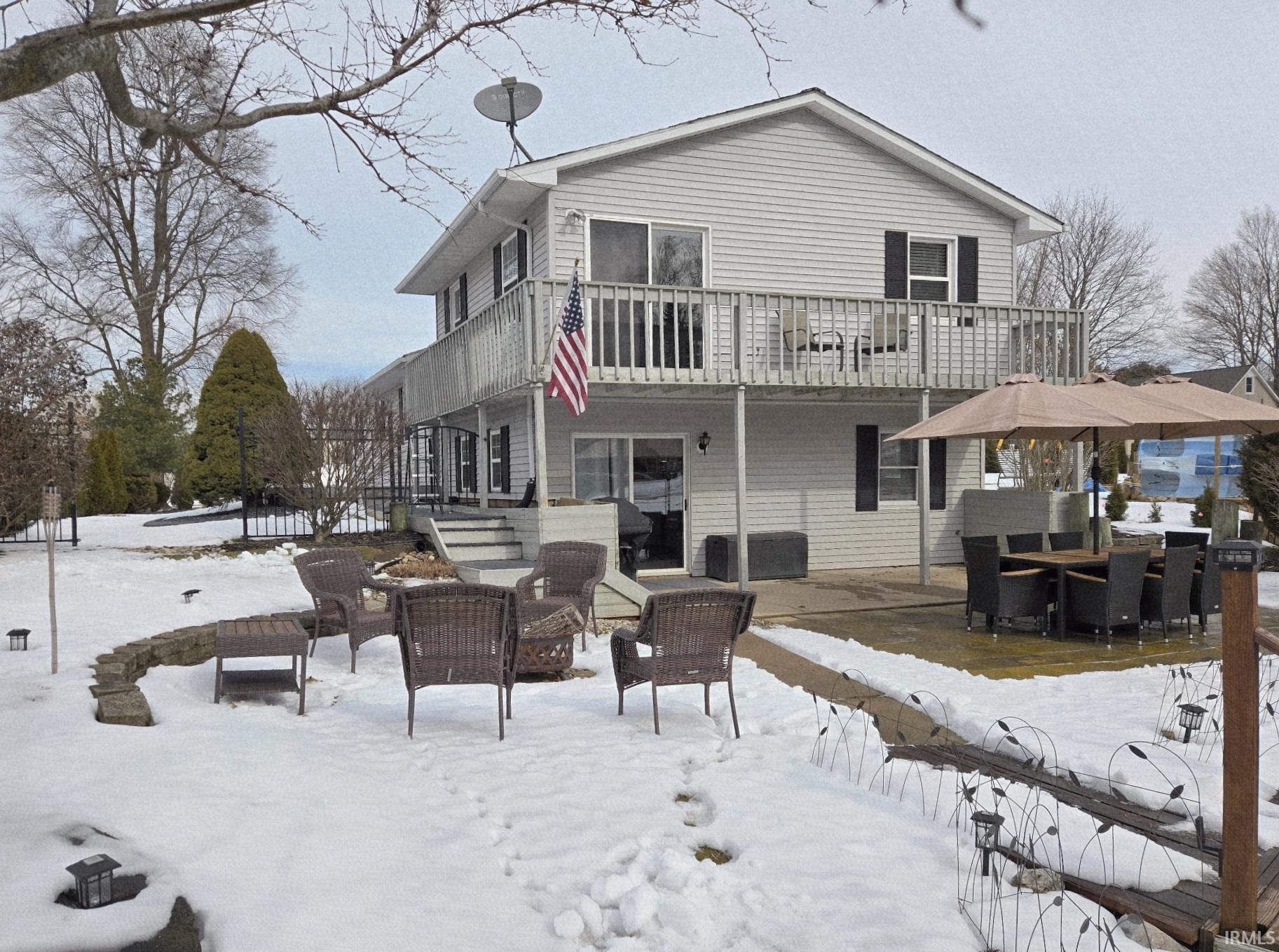 Image 3: Snow covered rear of property with a patio area, a deck, and outdoor lounge area, Back Of Structure