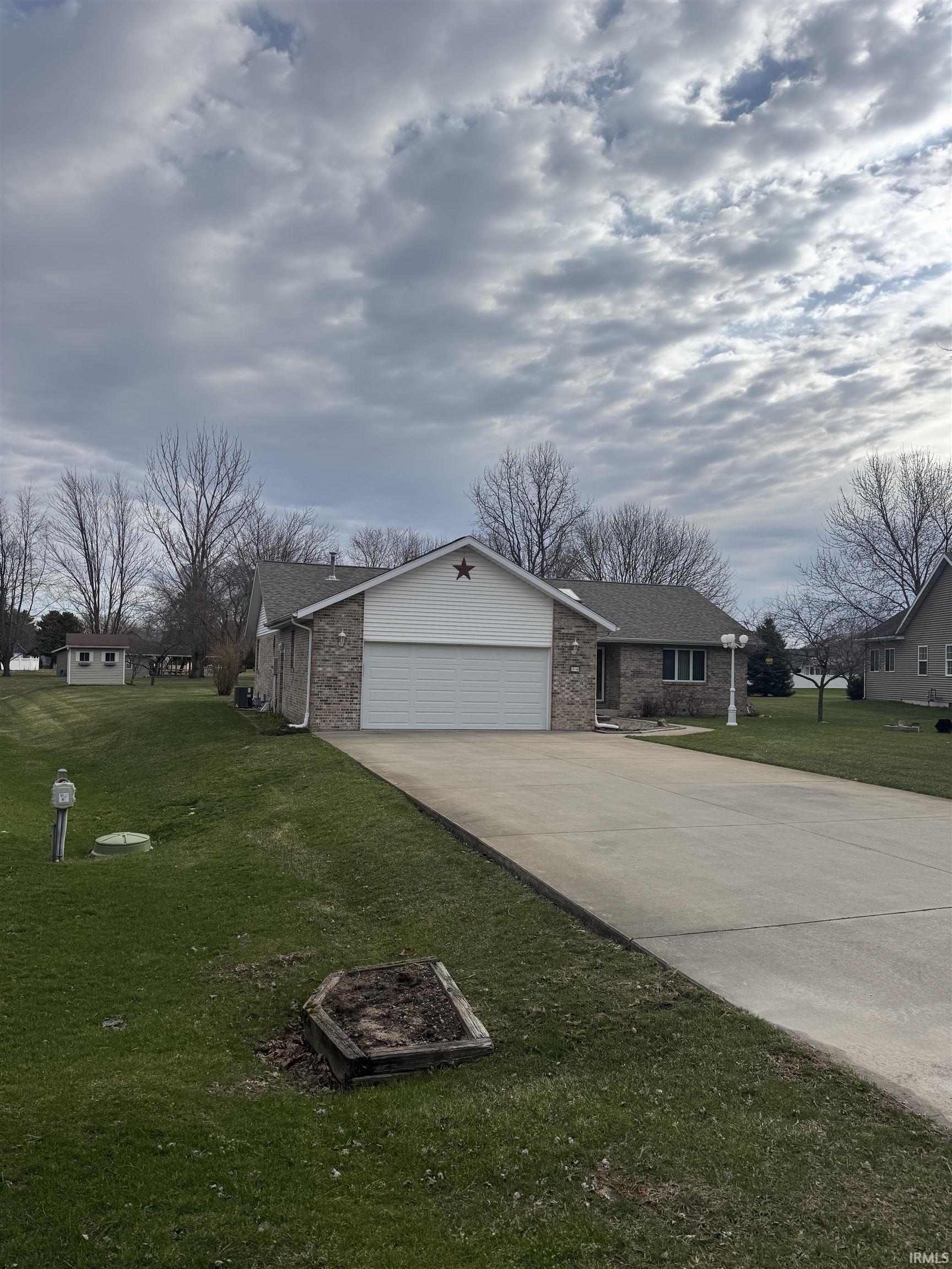 Image 0: View of front of home with driveway, a garage, a front yard, brick siding, and a residential view, Front Of Structure Image 0: View of front of home with driveway, a garage, a front yard, brick siding, and a residential view, Front Of Structure