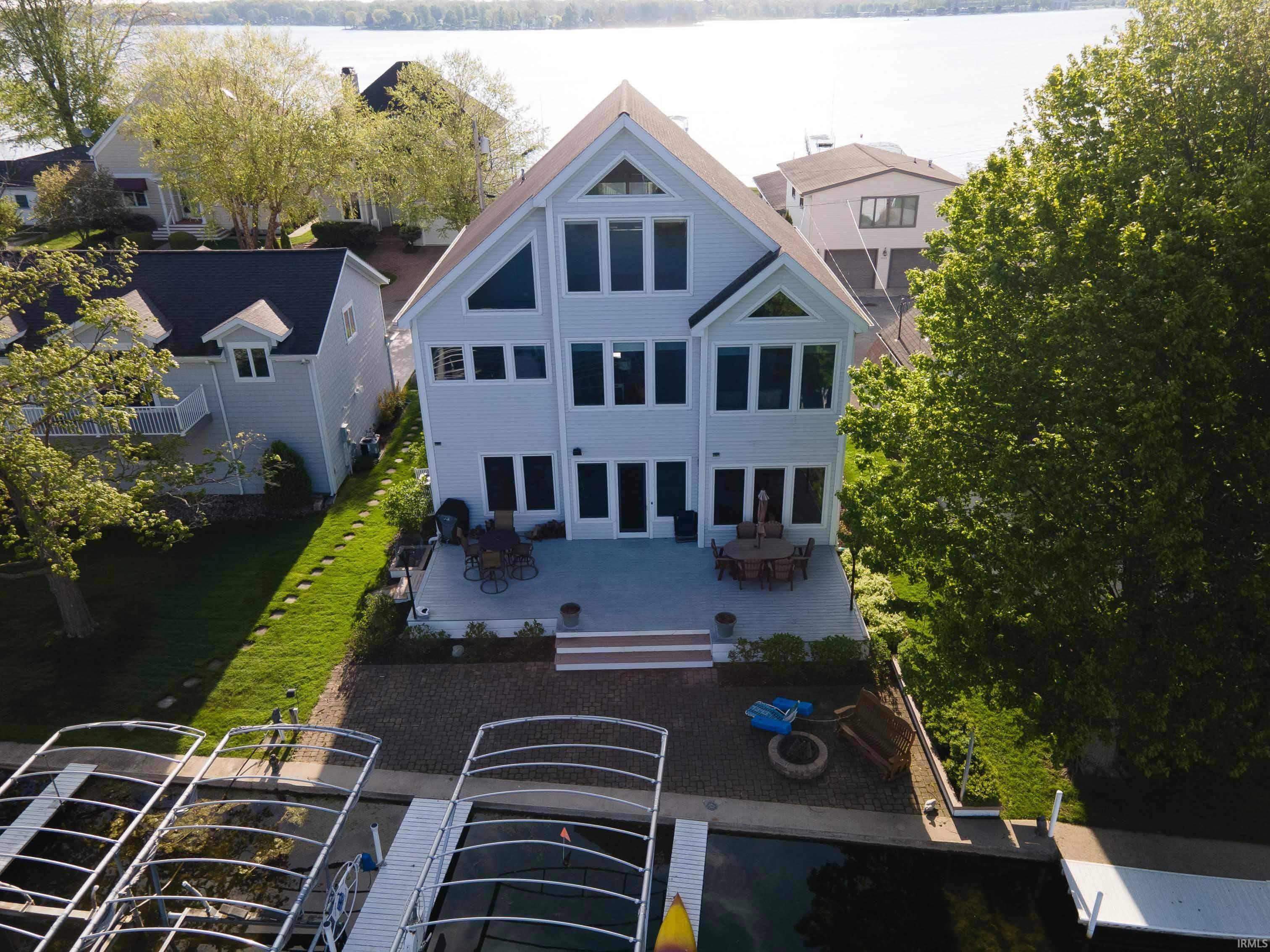 Image 2: Waterside residence featuring multiple levels of windows, a spacious rear patio, and a dedicated boat dock, Back Of Structure Image 2: Waterside residence featuring multiple levels of windows, a spacious rear patio, and a dedicated boat dock, Back Of Structure