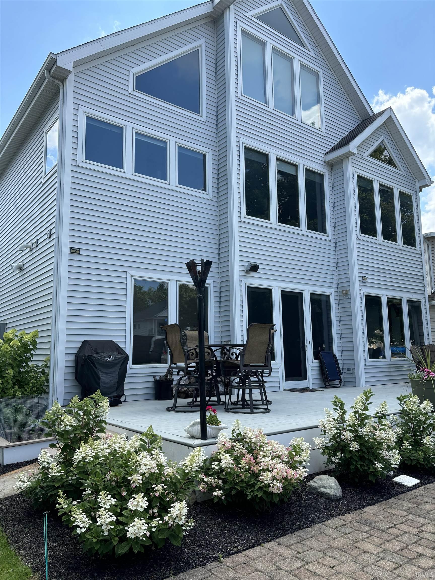 Image 3: Multi-level exterior featuring light-colored siding, a patio deck, and a brick paver pathway, Back Of Structure Image 3: Multi-level exterior featuring light-colored siding, a patio deck, and a brick paver pathway, Back Of Structure