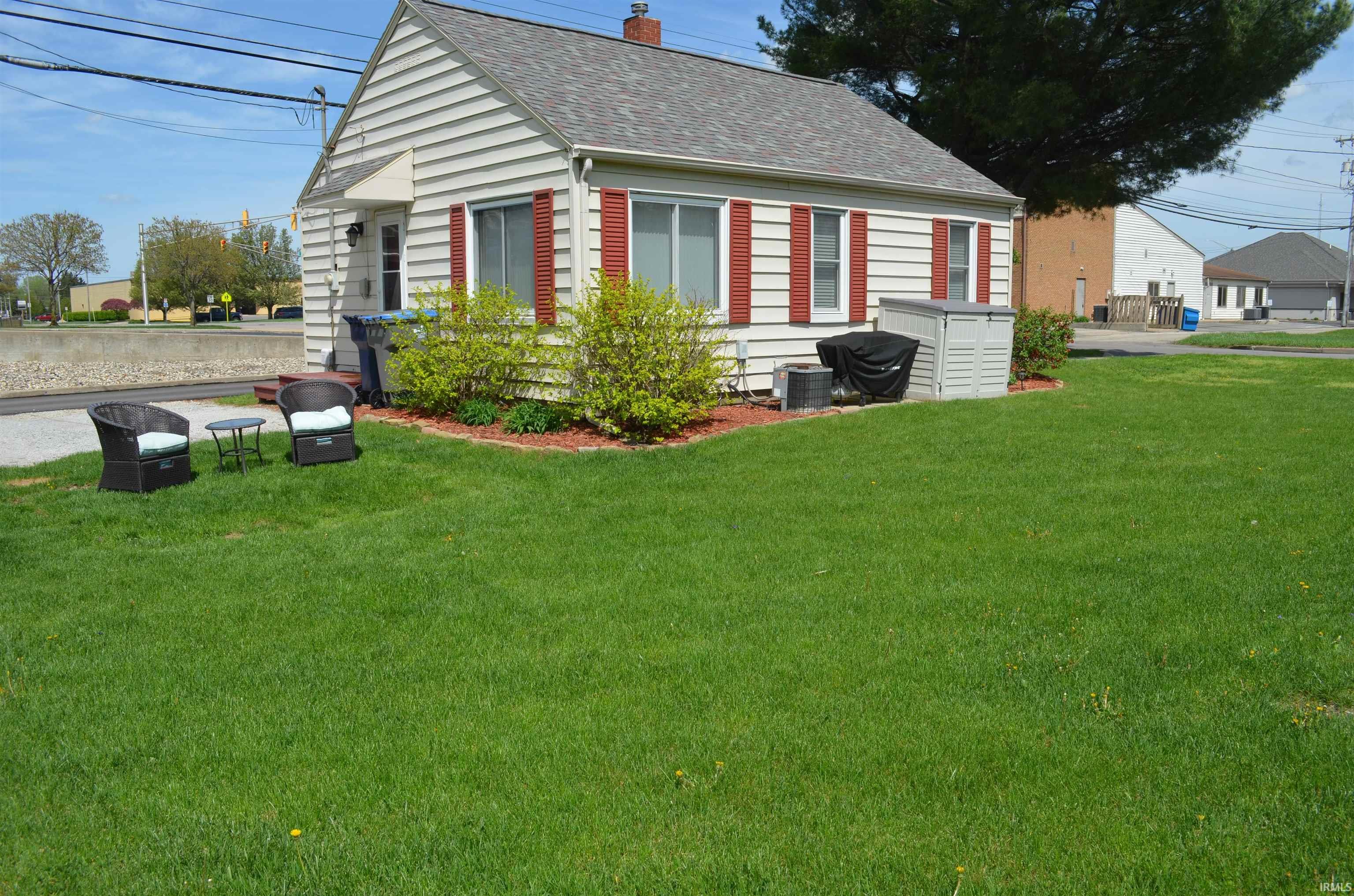 Image 2: Charming single-story residence featuring light-colored siding, red window shutters, and a gray shingled roof, Side Of Structure Image 2: Charming single-story residence featuring light-colored siding, red window shutters, and a gray shingled roof, Side Of Structure