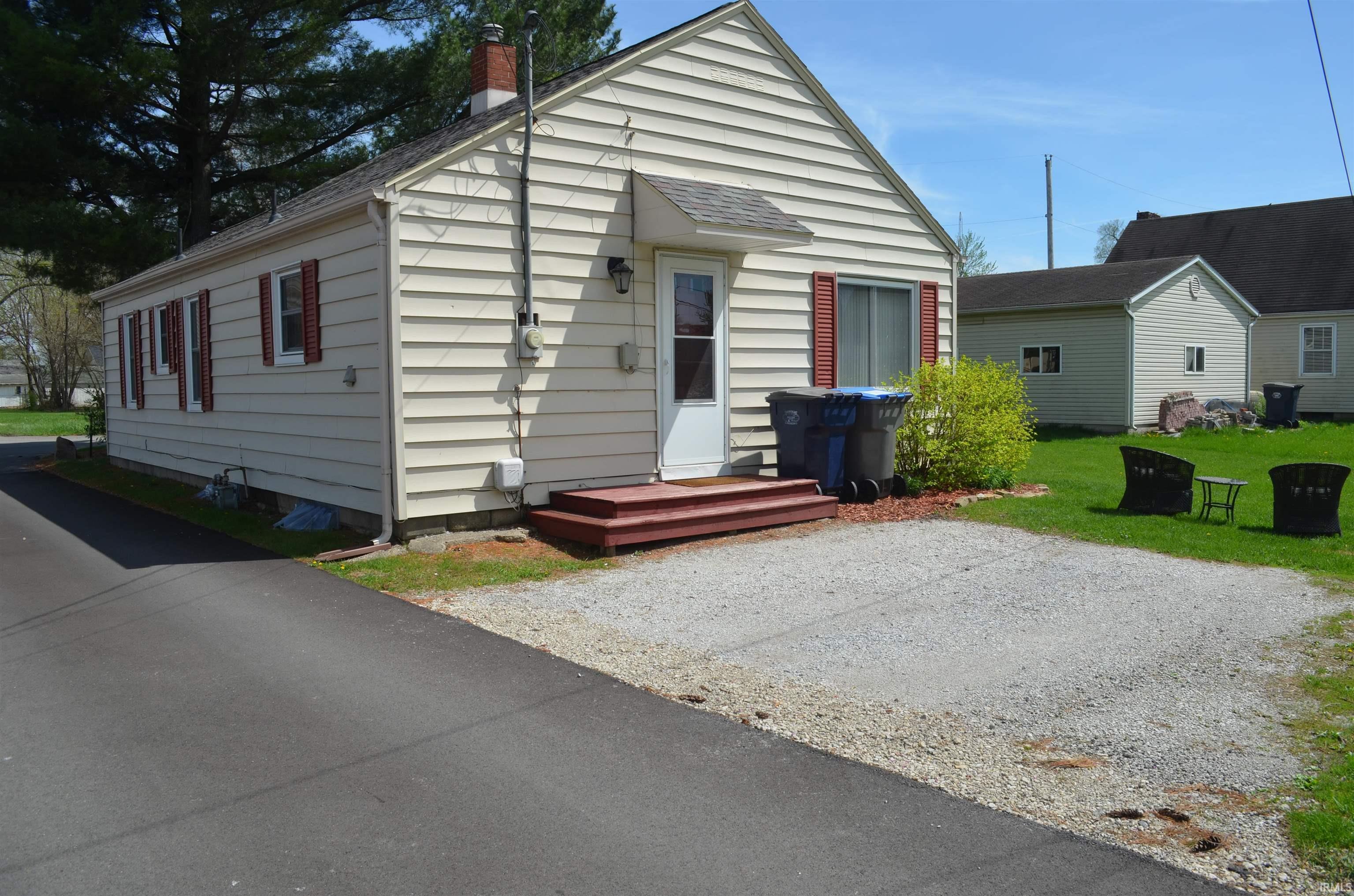 Image 3: Single-story residence featuring light-colored horizontal siding and a prominent side entry with a small awning, Front Of Structure Image 3: Single-story residence featuring light-colored horizontal siding and a prominent side entry with a small awning, Front Of Structure