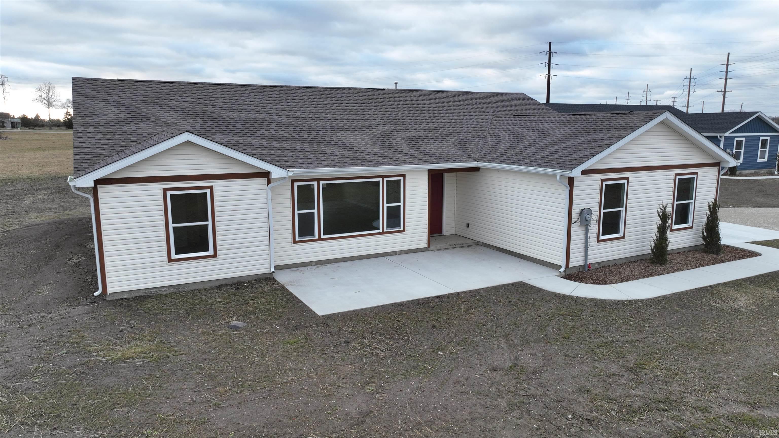 Image 0: View of front of home with a shingled roof and a patio, Front Of Structure