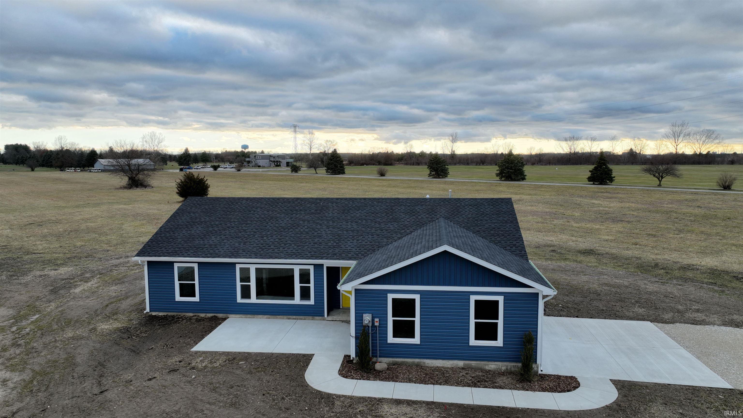 Image 2: View of front of home featuring a view of rural / pastoral area, roof with shingles, a patio area, and a front lawn, Front Of Structure