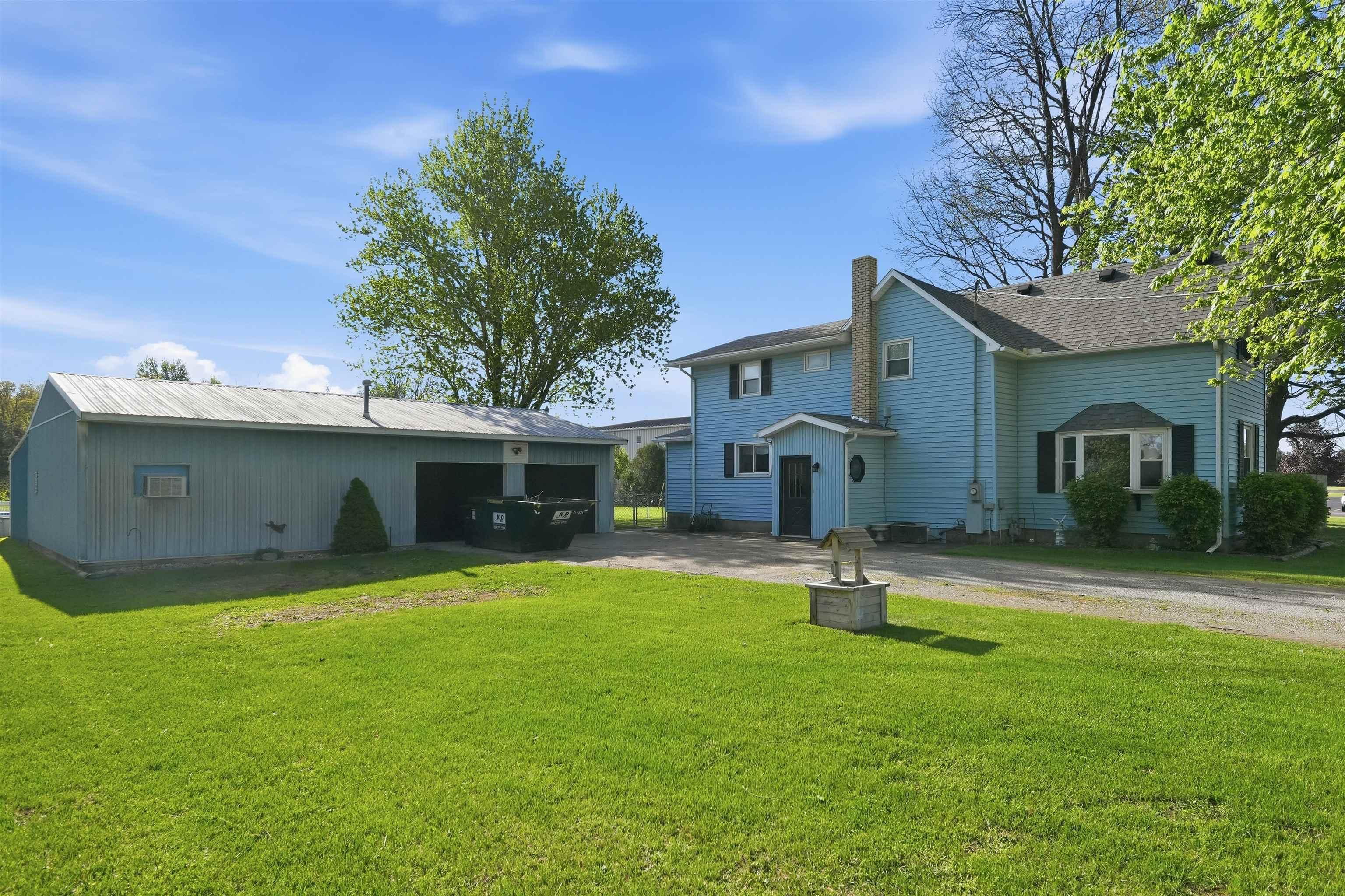 Image 1: Two-story residence featuring blue siding, a dark roof, and a prominent chimney