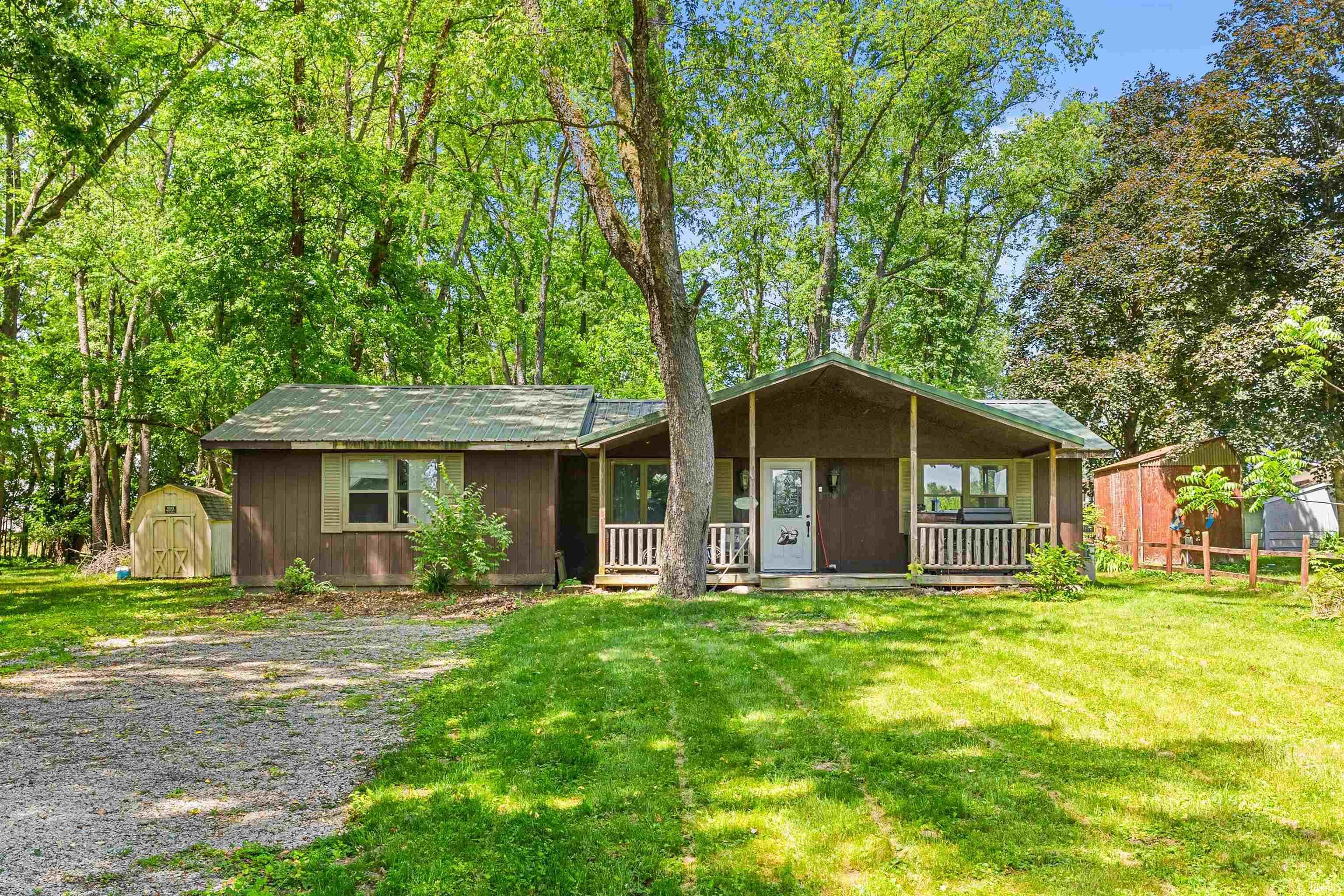 Image 0: Ranch-style exterior with a covered porch, wood siding, and a green metal roof, Front Of Structure Image 0: Ranch-style exterior with a covered porch, wood siding, and a green metal roof, Front Of Structure