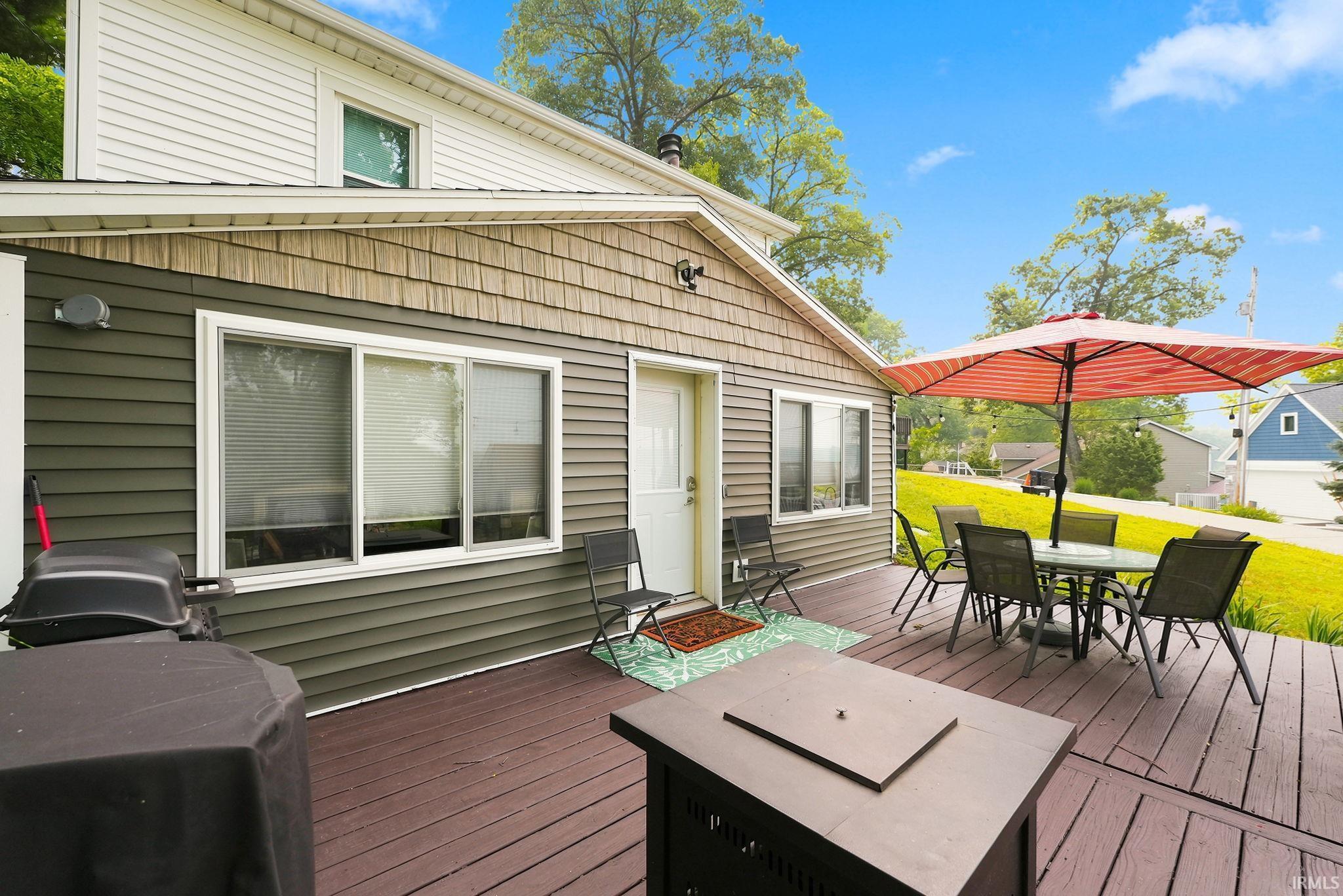 Image 1: Expansive wood-finish deck with multiple seating areas, Deck