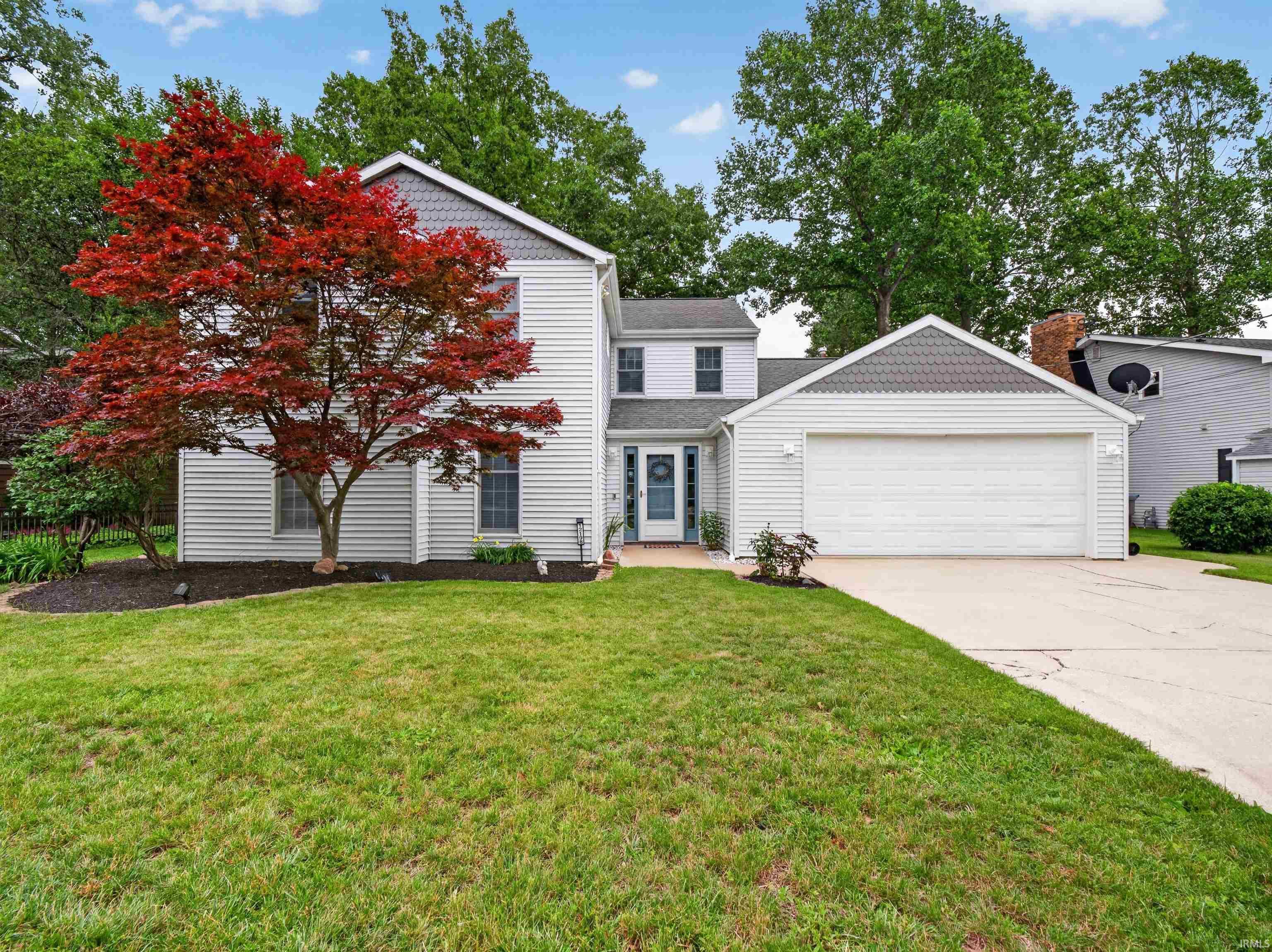 Image 1: Two-story residence featuring white horizontal siding, a two-car garage, and a concrete driveway, Front Of Structure