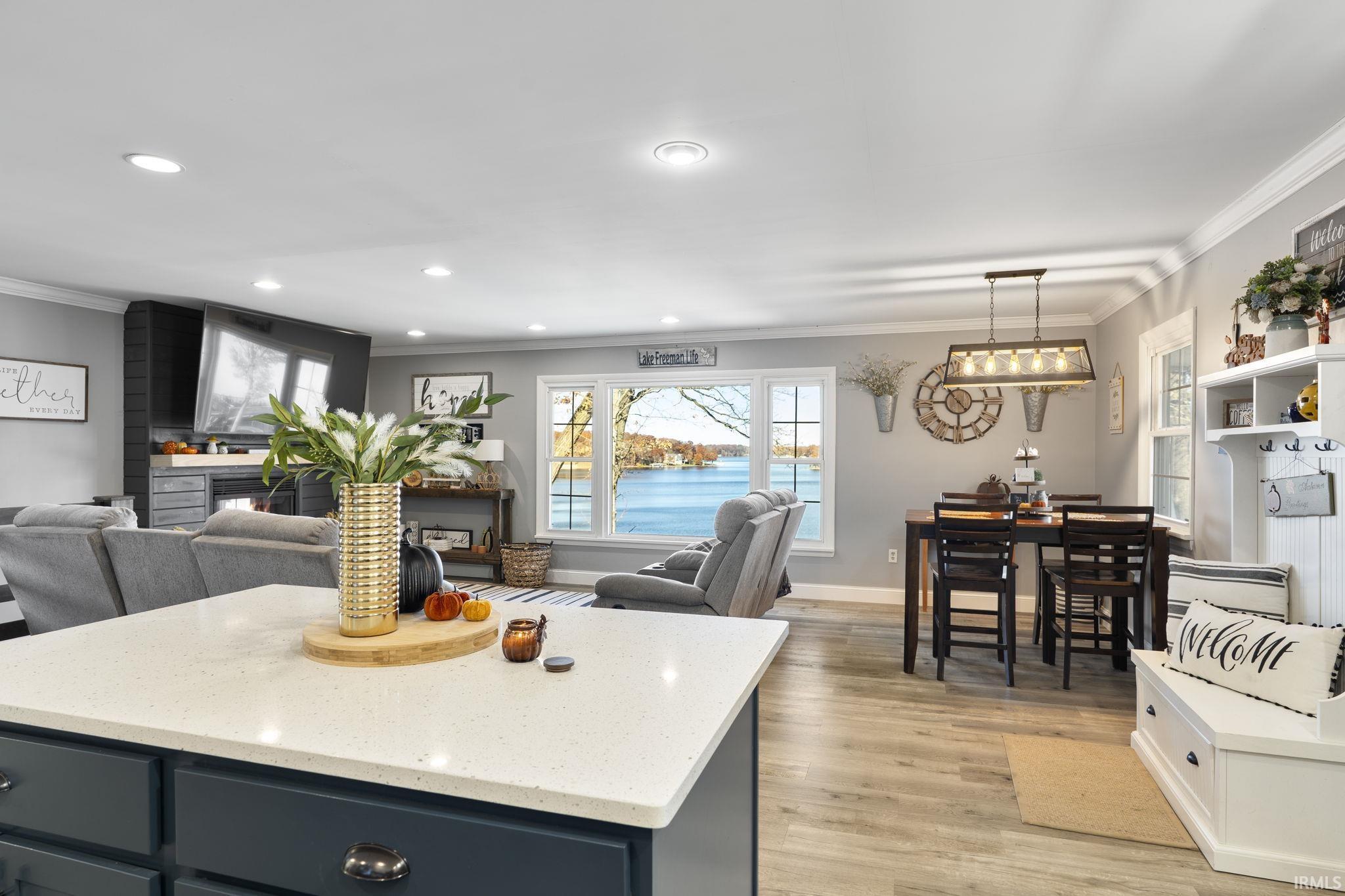 Image 3: Kitchen featuring ornamental molding, decorative light fixtures, light stone countertops, light wood-style flooring, and open floor plan, Kitchen