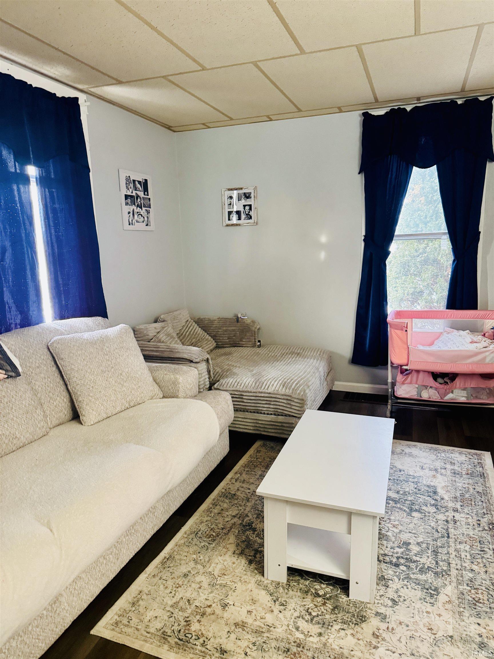 Image 1: Living room featuring a drop ceiling and wood finished floors, Living Room
