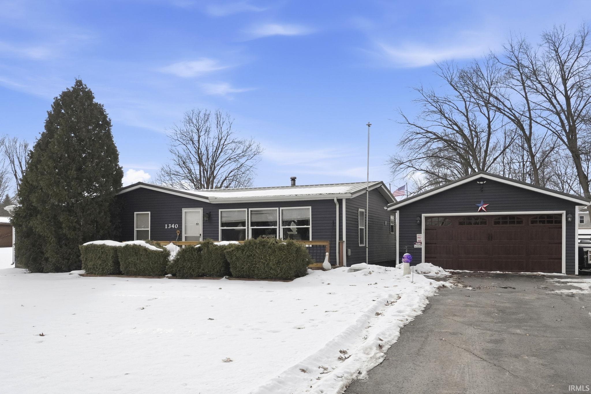 Image 0: Ranch-style home featuring a detached garage and an outdoor structure, Front Of Structure