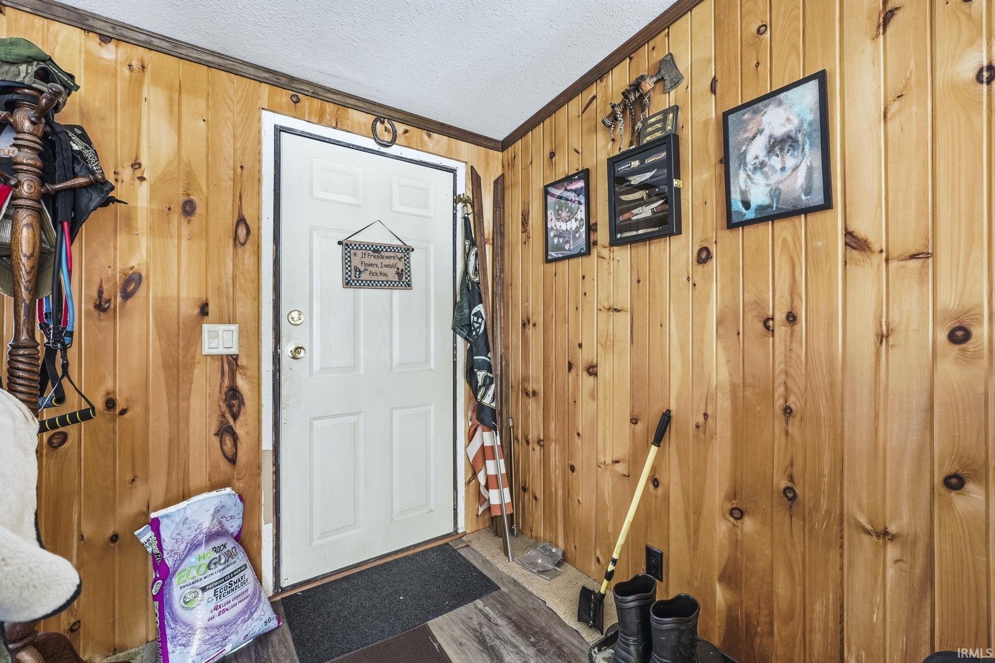 Image 2: Foyer with wood walls, a textured ceiling, and ornamental molding, Entrance Foyer