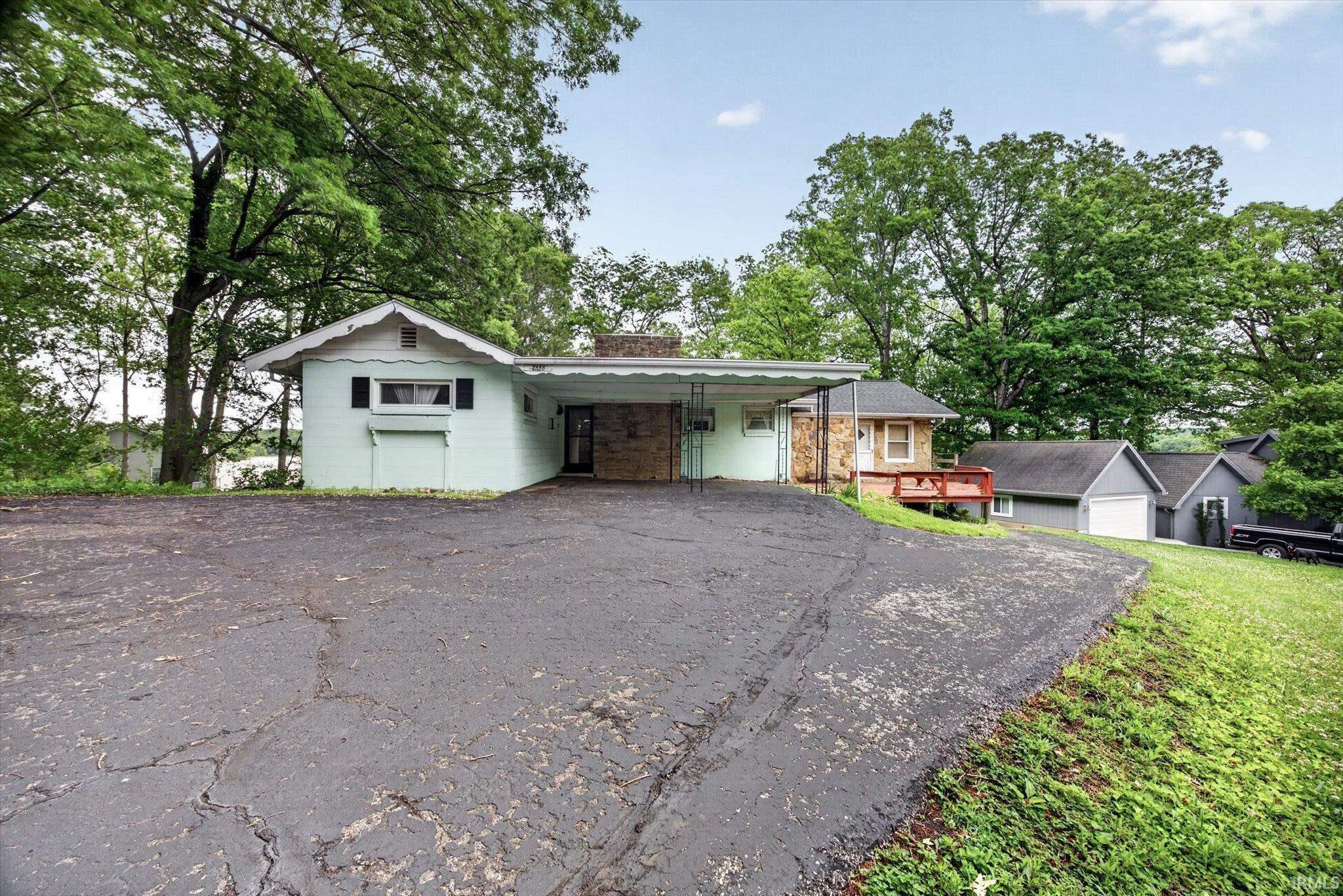 Image 0: Single-story residence featuring light green siding and a covered carport entrance, Front Of Structure Image 0: Single-story residence featuring light green siding and a covered carport entrance, Front Of Structure