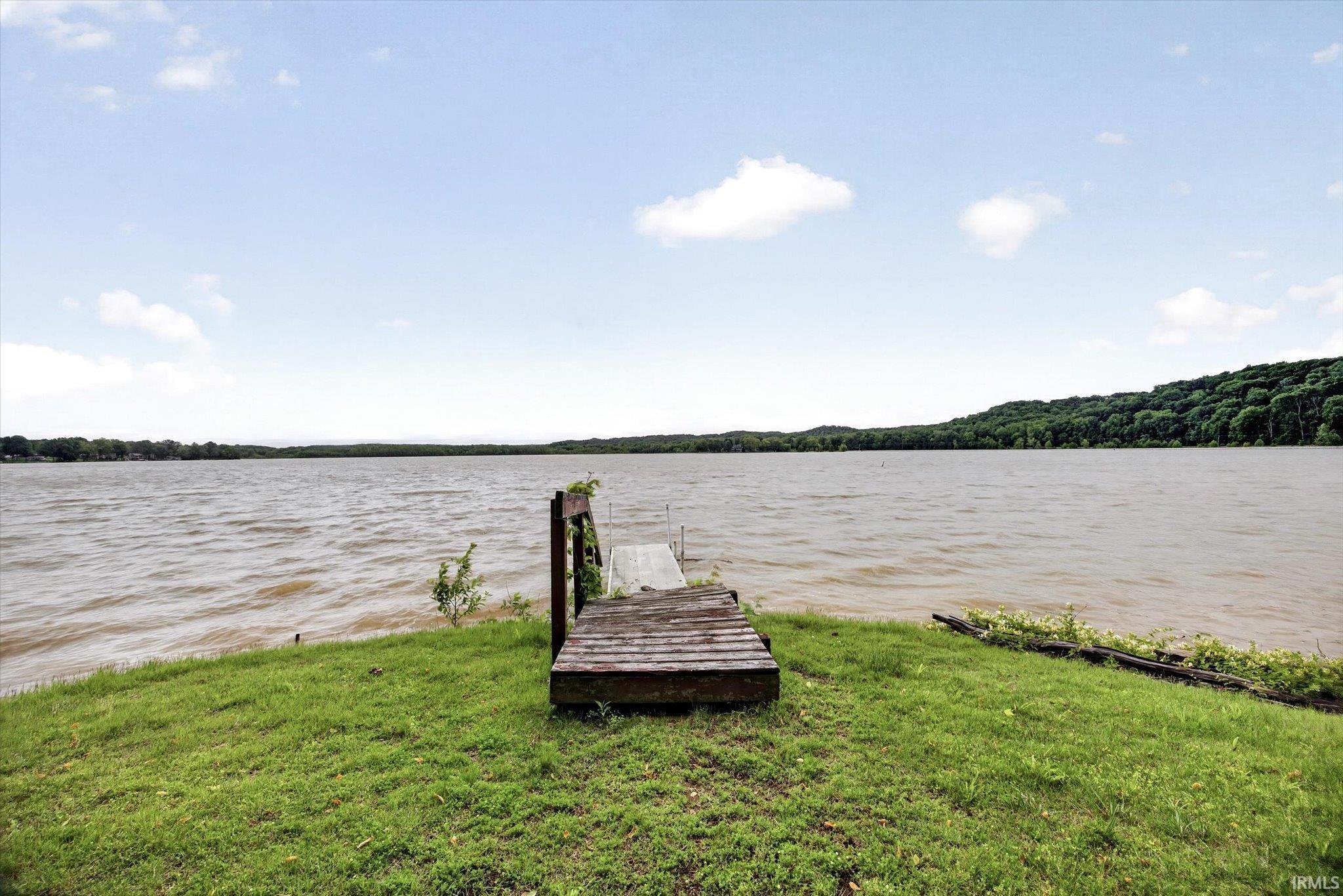 Image 1: Waterfront property featuring a wooden dock, expansive water frontage, and a grassy shoreline, Dock Image 1: Waterfront property featuring a wooden dock, expansive water frontage, and a grassy shoreline, Dock