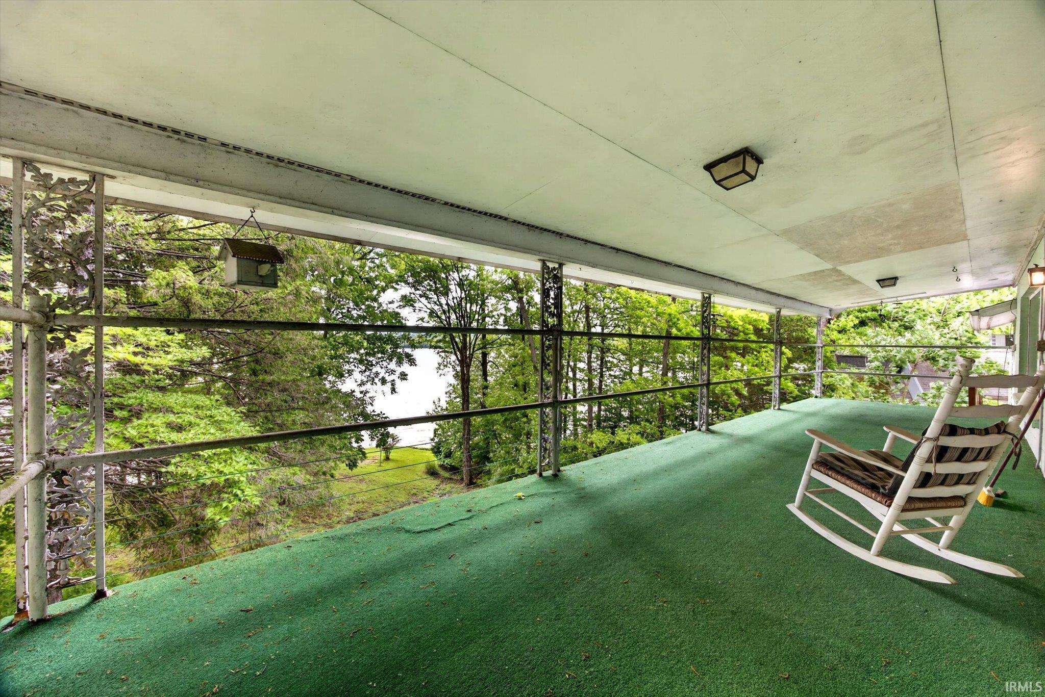 Image 3: Spacious covered porch with green turf flooring, white overhead lighting, and horizontal railings, Sun Room Image 3: Spacious covered porch with green turf flooring, white overhead lighting, and horizontal railings, Sun Room