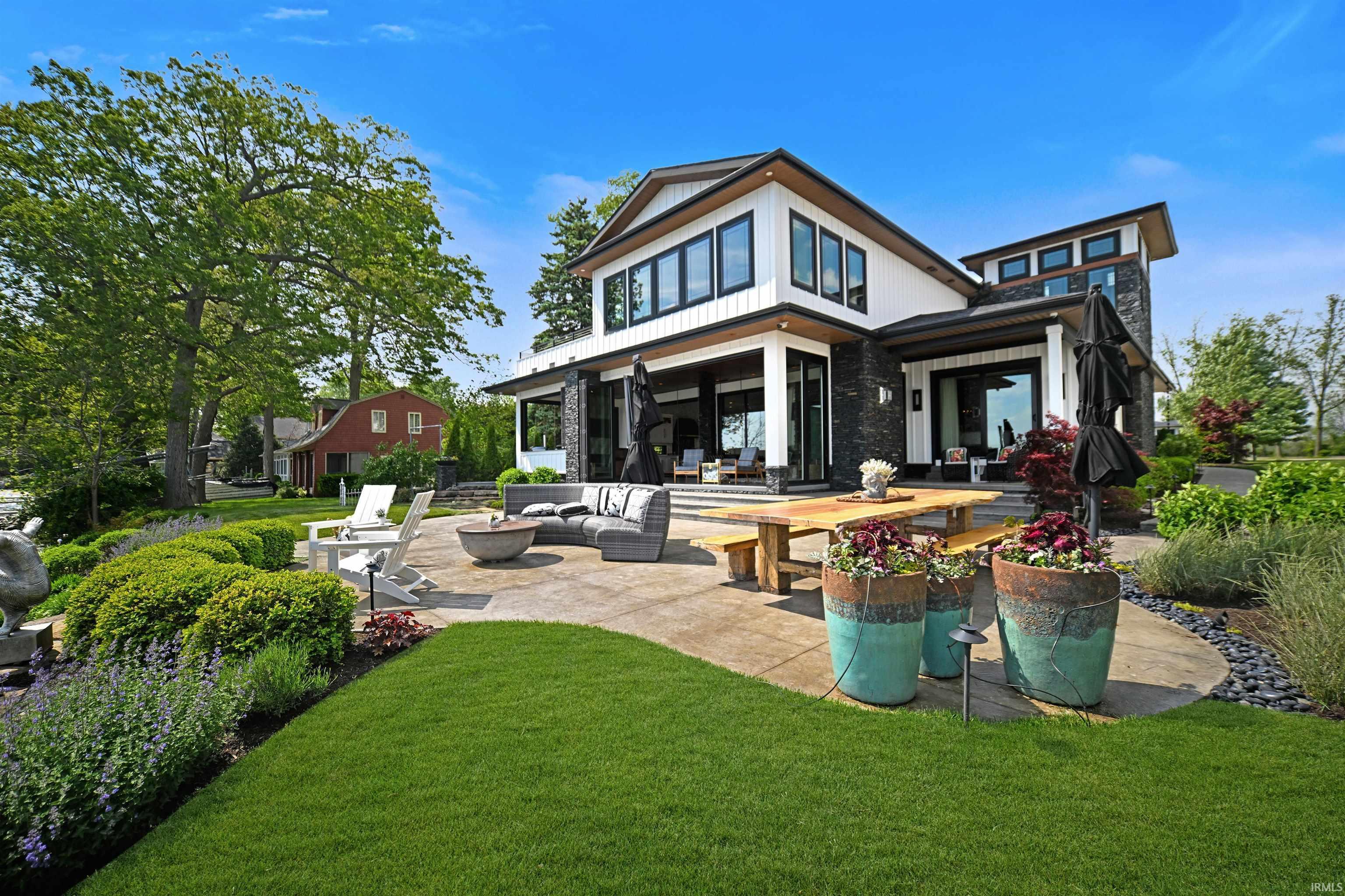 Image 3: Modern exterior featuring white siding, dark stone accents, and black-framed windows, Back Of Structure Image 3: Modern exterior featuring white siding, dark stone accents, and black-framed windows, Back Of Structure