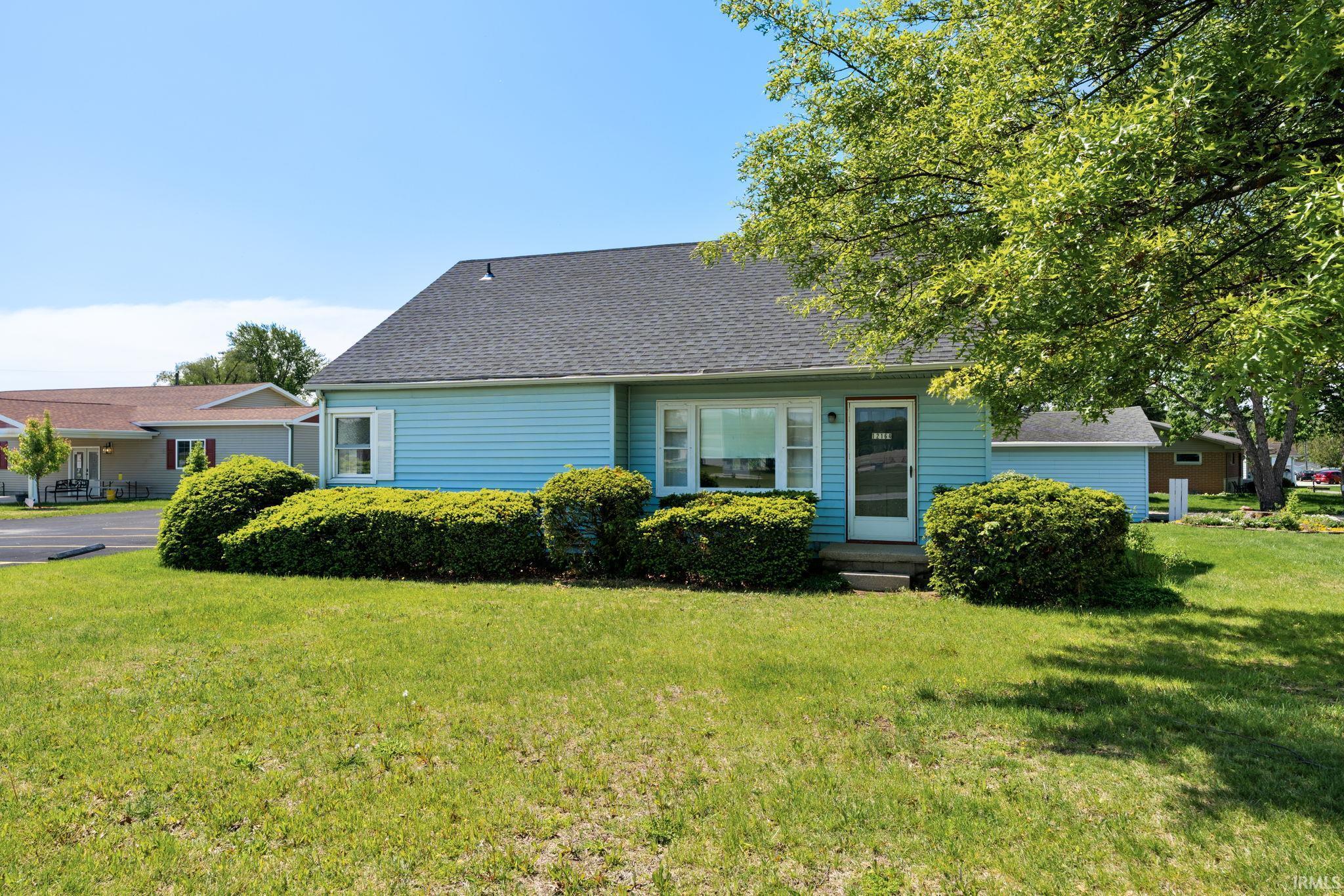 Image 2: Light blue siding exterior featuring white trim windows and a dark shingle roof, Front Of Structure Image 2: Light blue siding exterior featuring white trim windows and a dark shingle roof, Front Of Structure