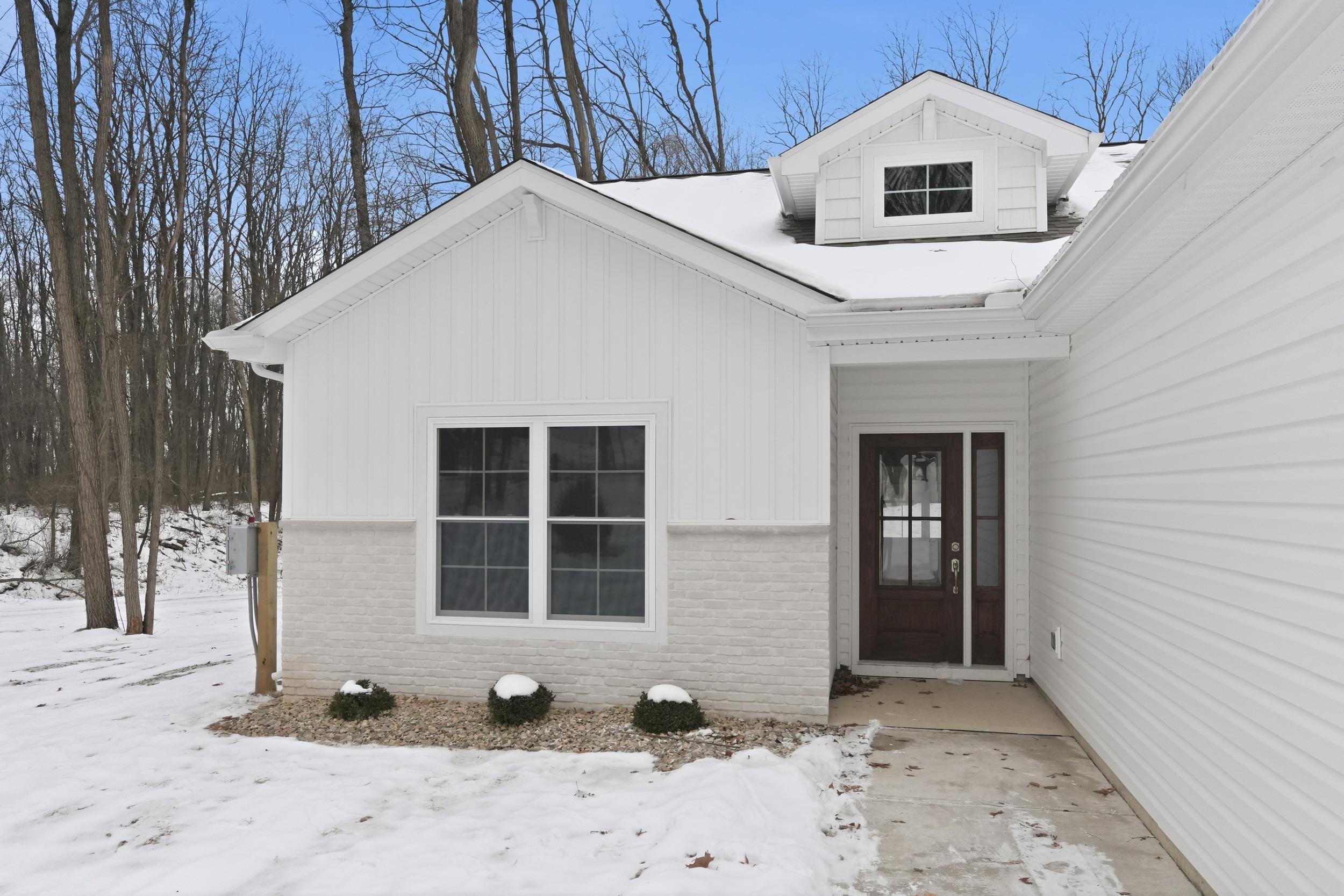 Image 3: Snow covered property entrance with brick siding, Entry