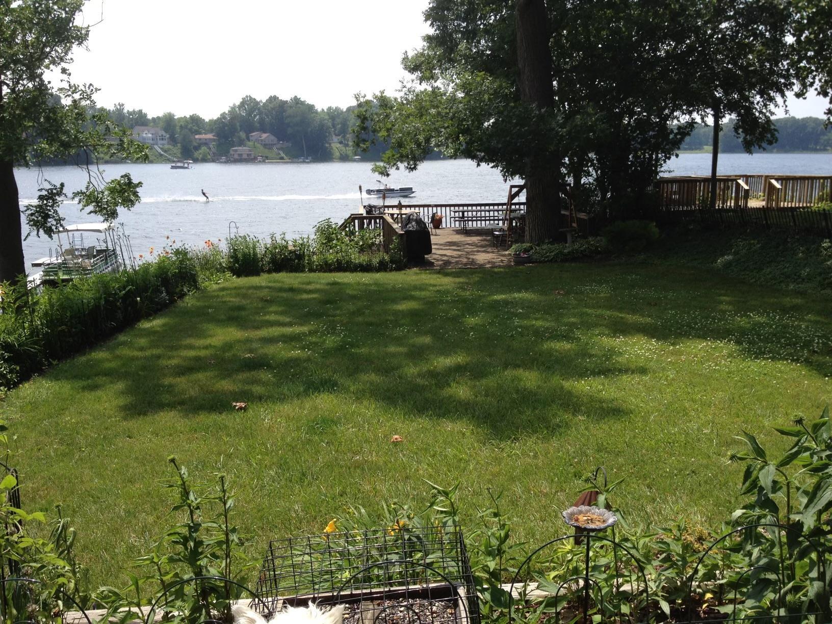 Image 3: View of grassy yard with a water view and a dock, Yard