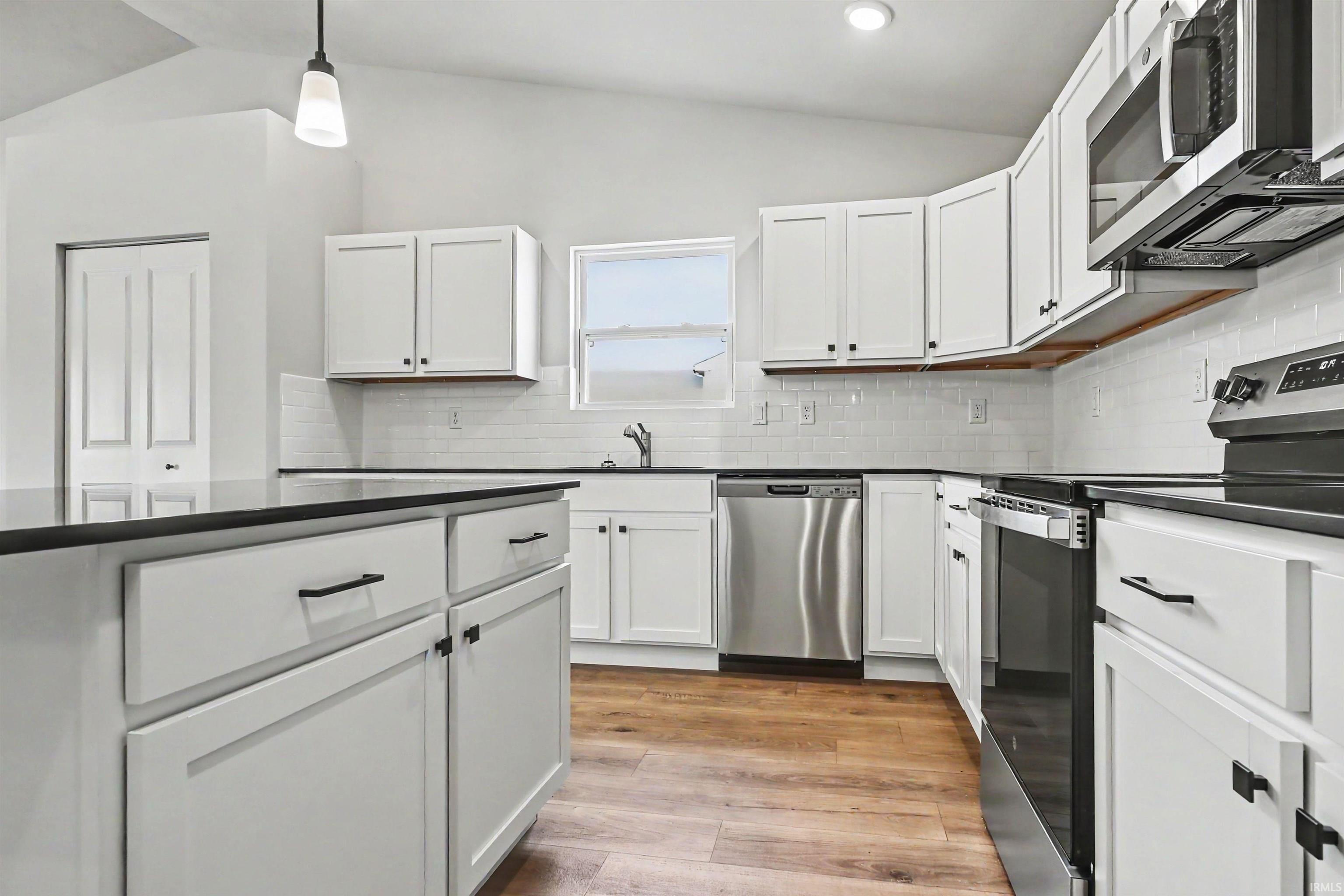 Image 3: The kitchen includes Quartz counters with subway tile backsplash, large center island with extended edge counter and pendant lighting above. Stainless steel appliances are included!, Kitchen Image 3: The kitchen includes Quartz counters with subway tile backsplash, large center island with extended edge counter and pendant lighting above. Stainless steel appliances are included!, Kitchen