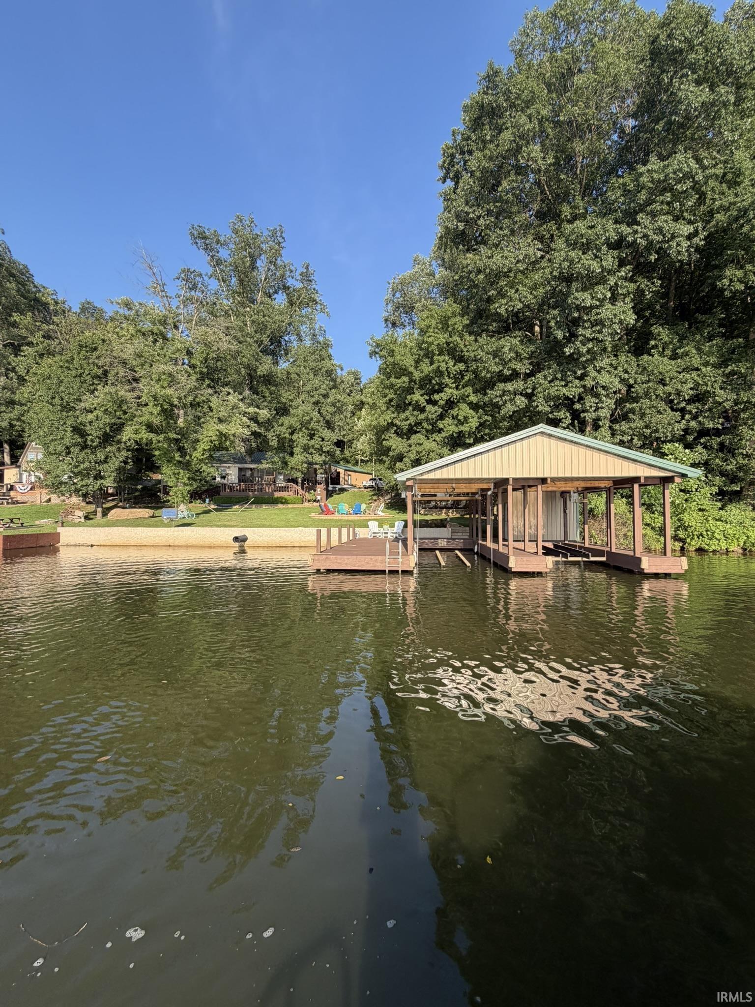 Image 2: Waterfront property featuring a covered boat dock, a wooden pier, and a sandy shoreline, Dock Image 2: Waterfront property featuring a covered boat dock, a wooden pier, and a sandy shoreline, Dock