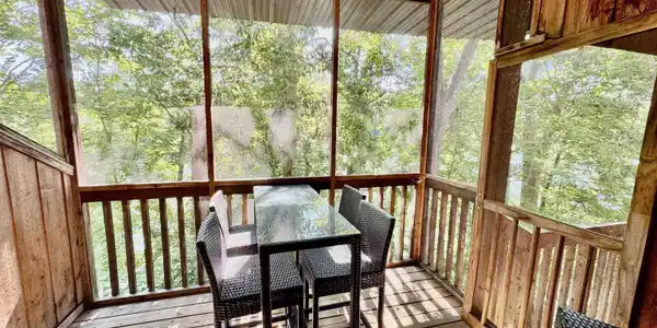 Image 1: Screened porch with expansive windows and wood-finish railings, offering abundant natural light and sheltered outdoor entertaining space, Sun Room Image 1: Screened porch with expansive windows and wood-finish railings, offering abundant natural light and sheltered outdoor entertaining space, Sun Room