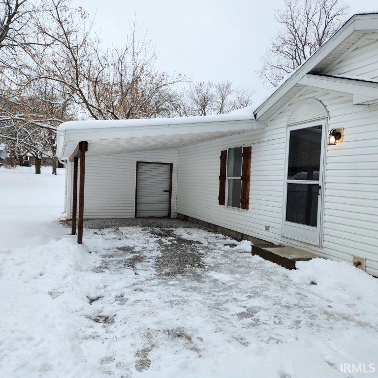 Image 1: View of snowy exterior with a carport, Side Of Structure Image 1: View of snowy exterior with a carport, Side Of Structure
