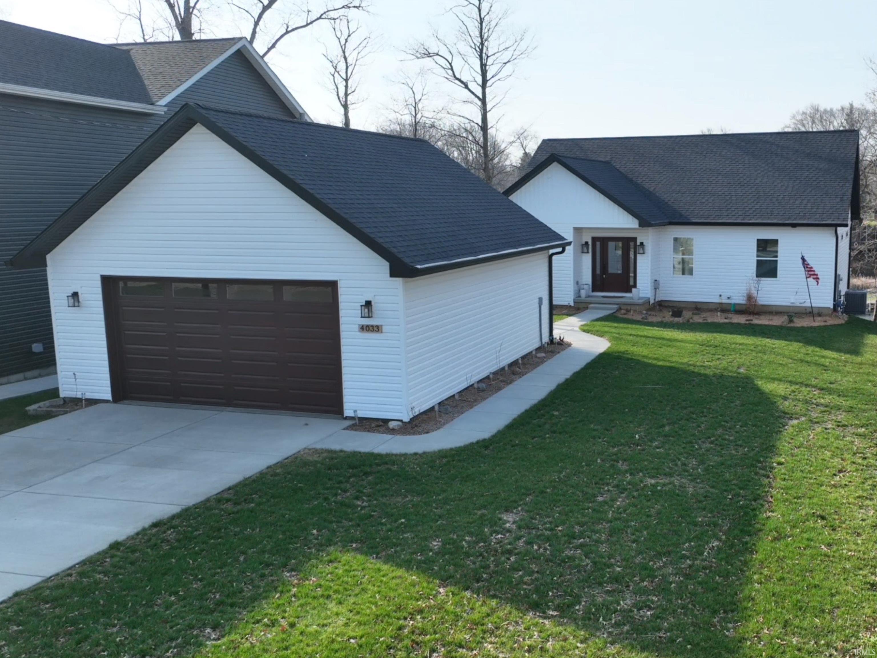 Image 1: View of front facade with a front yard, driveway, a shingled roof, and an attached garage, Front Of Structure