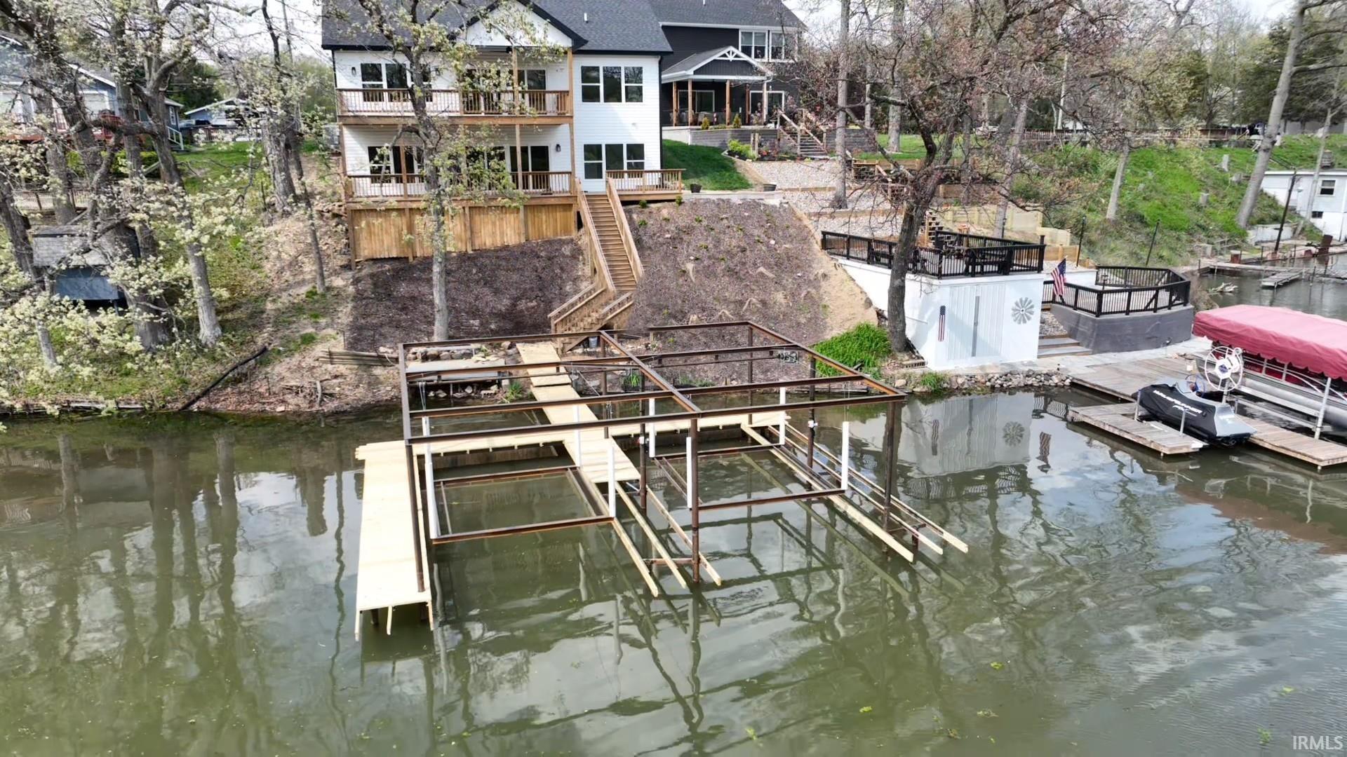 Image 3: Multi-level waterfront residence featuring a new dock structure, tiered deck spaces, and a lower-level lakeside patio area, Dock