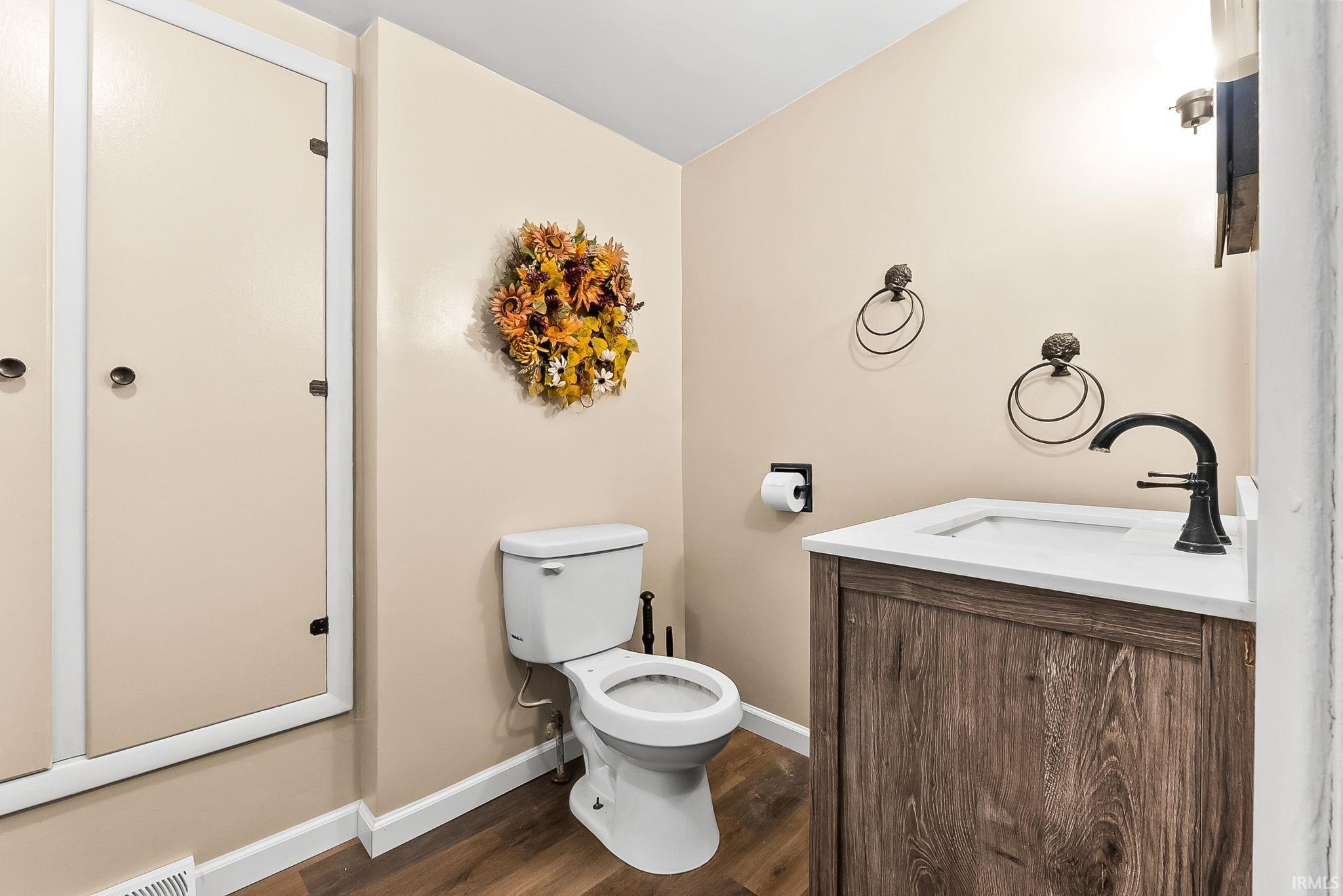 Image 1: Bathroom featuring vanity and dark wood finished floors, Bathroom