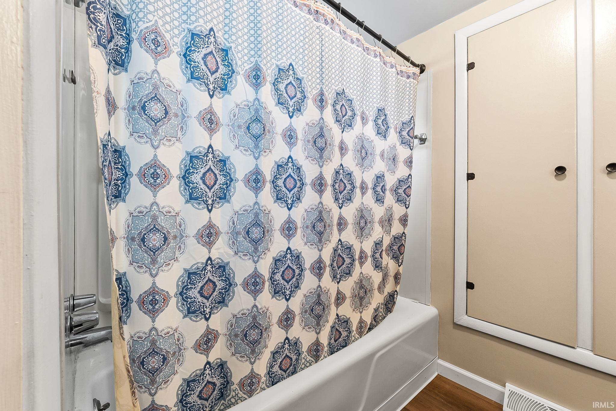 Image 2: Bathroom with shower / bath combo and dark wood finished floors, Bathroom