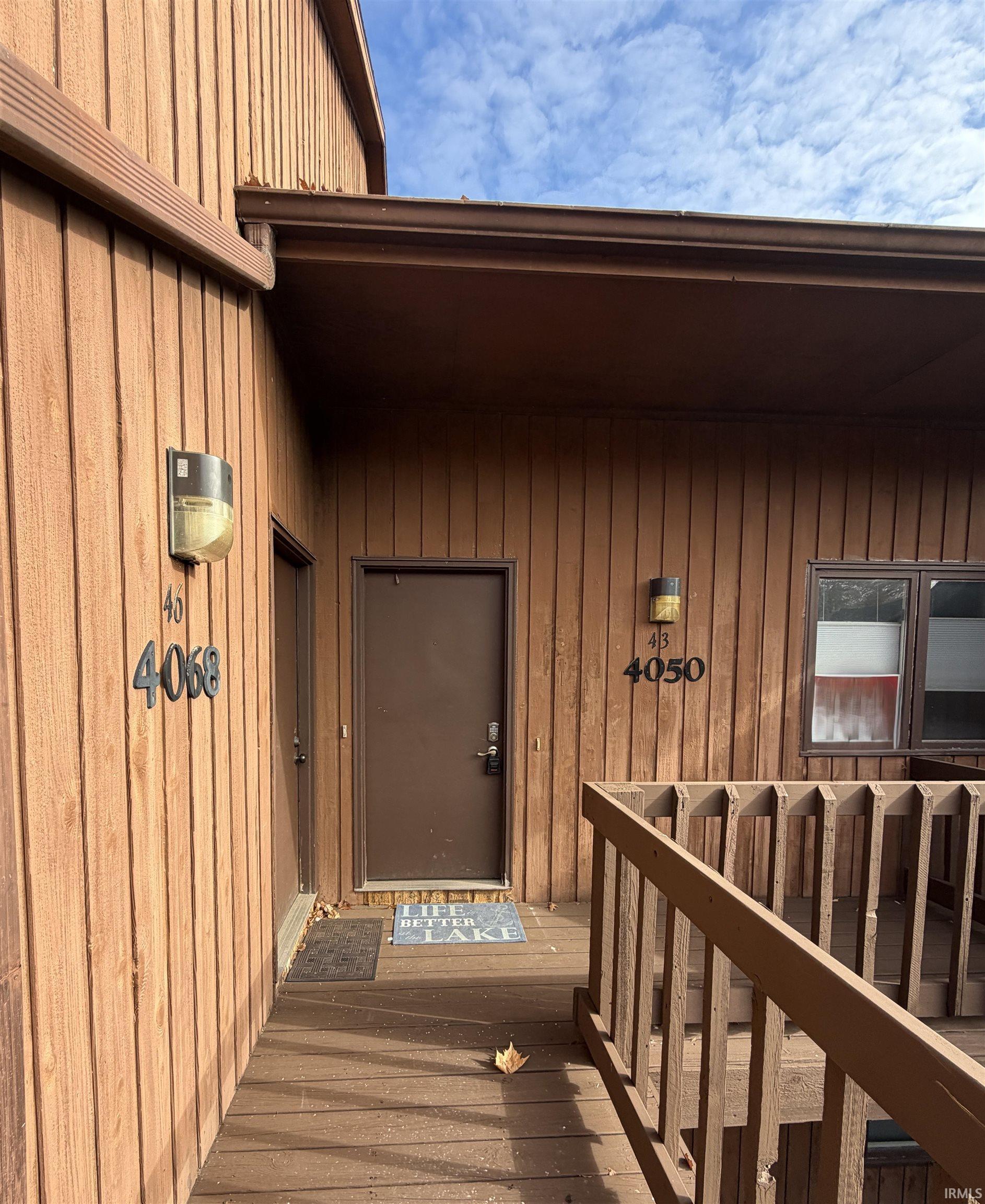 Image 2: View of exterior entry featuring a wooden deck and board and batten siding, Entry Image 2: View of exterior entry featuring a wooden deck and board and batten siding, Entry