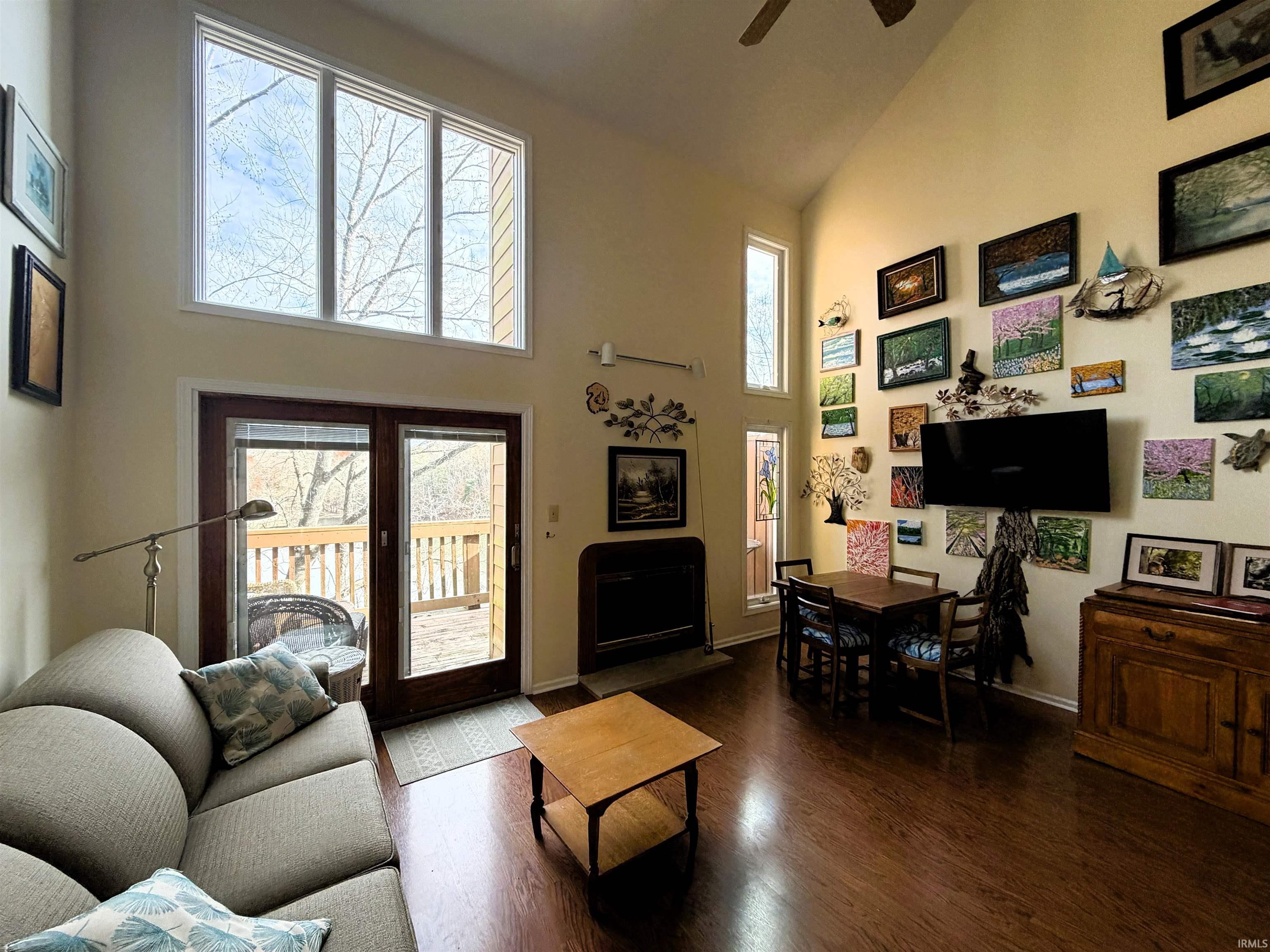 Image 3: Living area featuring high vaulted ceiling, plenty of natural light, ceiling fan, and fireplace, Living Room Image 3: Living area featuring high vaulted ceiling, plenty of natural light, ceiling fan, and fireplace, Living Room
