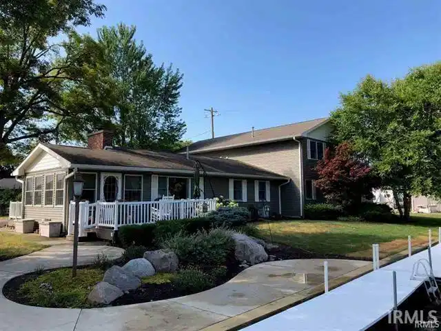 Image 0: View of front of house with a front yard, a chimney, and a sunroom, Front Of Structure Image 0: View of front of house with a front yard, a chimney, and a sunroom, Front Of Structure
