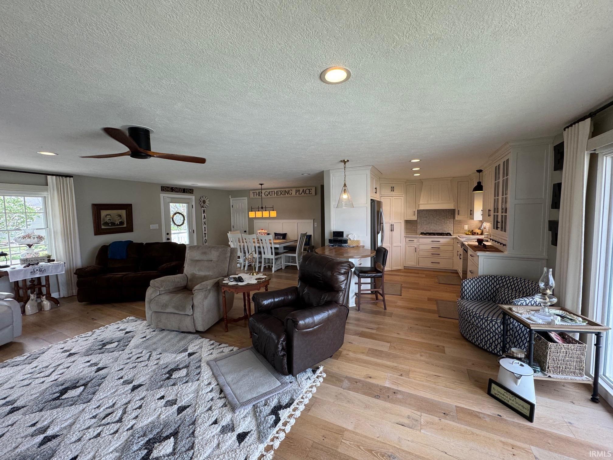 Image 2: Living room featuring healthy amount of natural light, light wood finished floors, recessed lighting, a textured ceiling, and a ceiling fan, Living Room