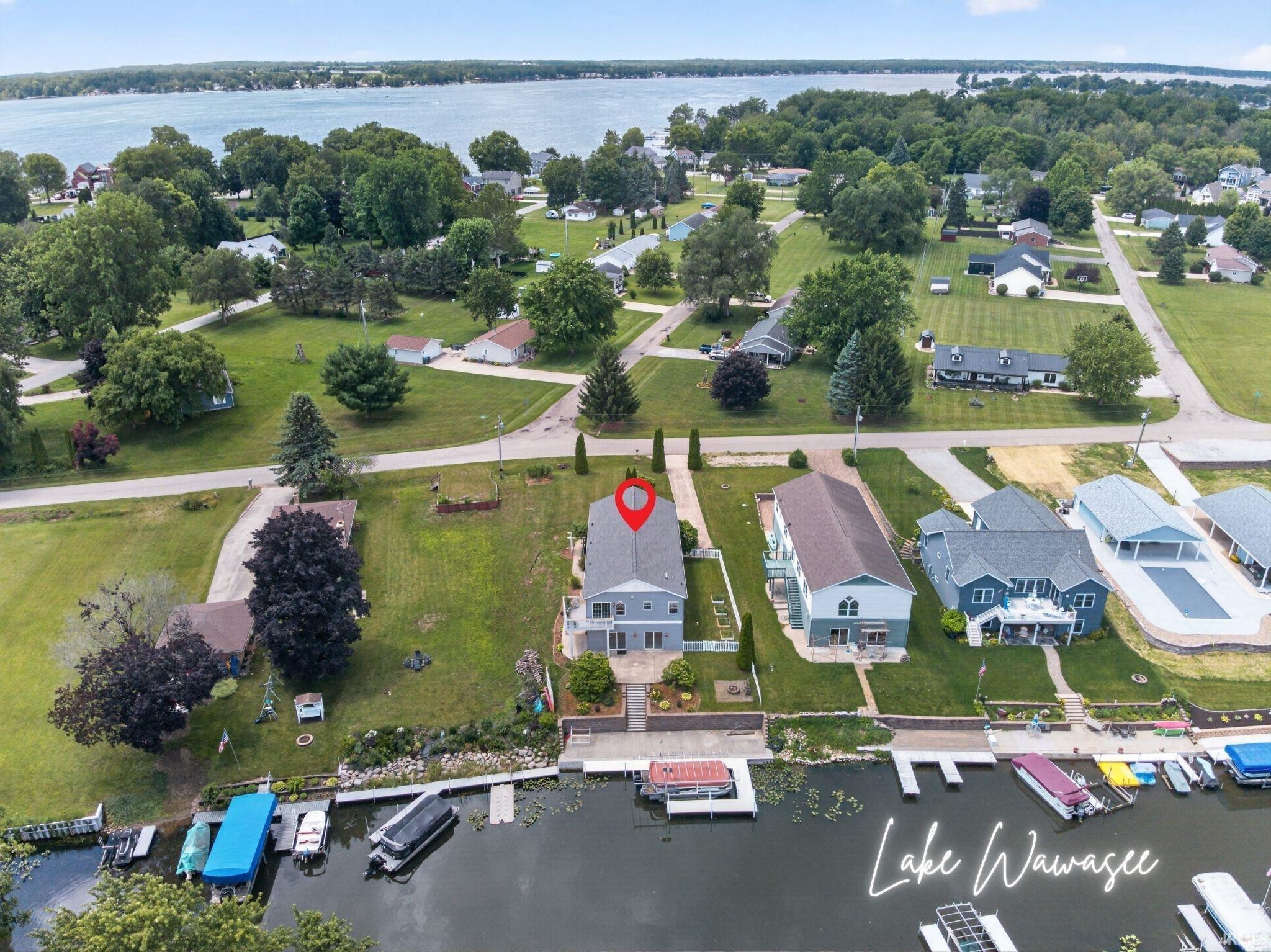 Image 1: Lakefront property featuring a private boat dock, spacious backyard, and a modern two-story residence with a light gray exterior, Aerial View