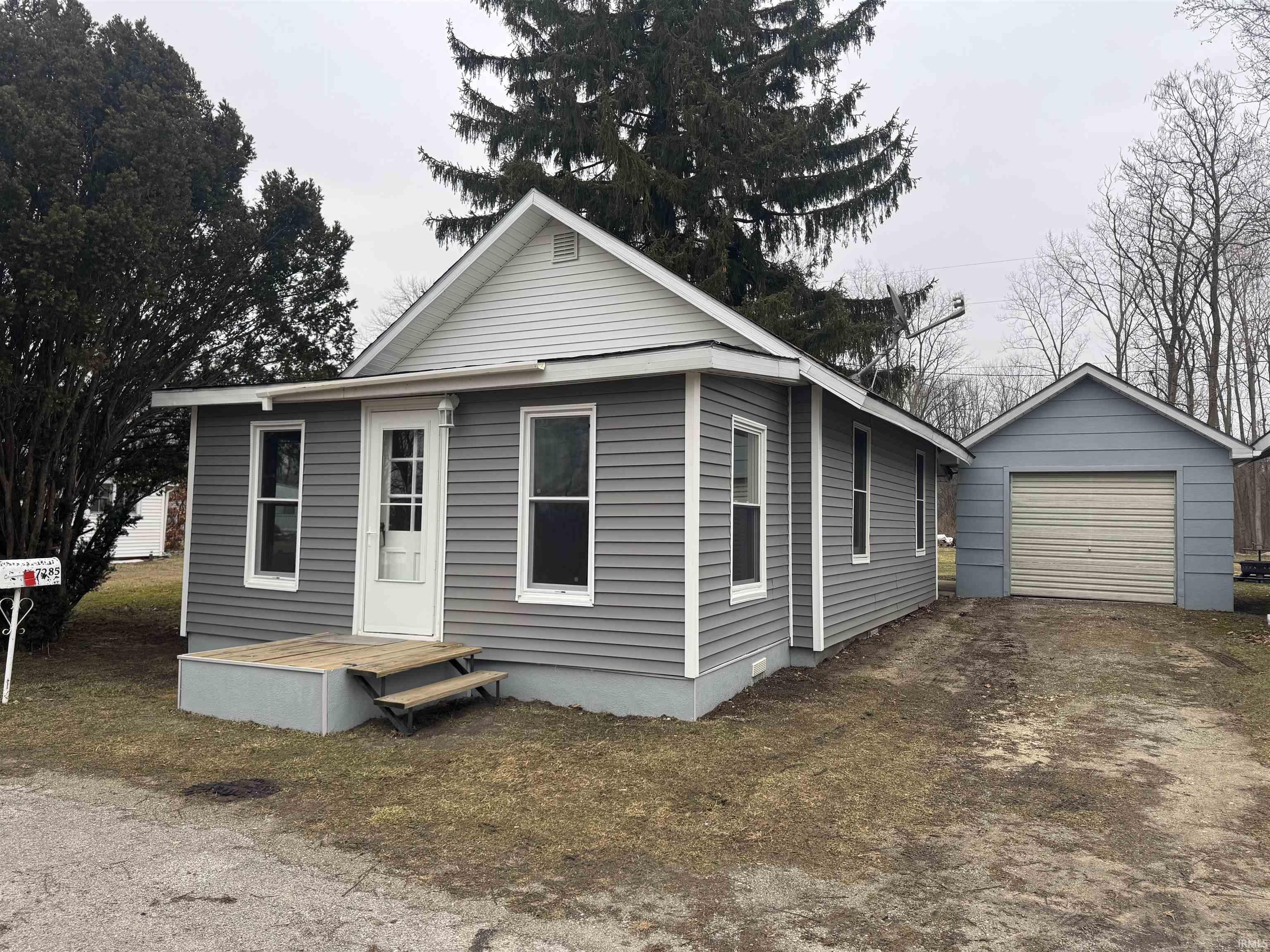 Image 0: View of front of property with dirt driveway and a detached garage, Front Of Structure